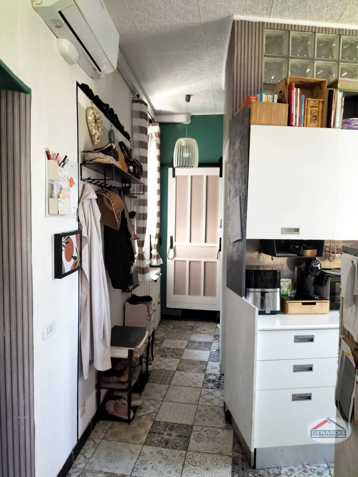 Schmaler Wohnbereich mit offener Küchenzeile und Garderobe