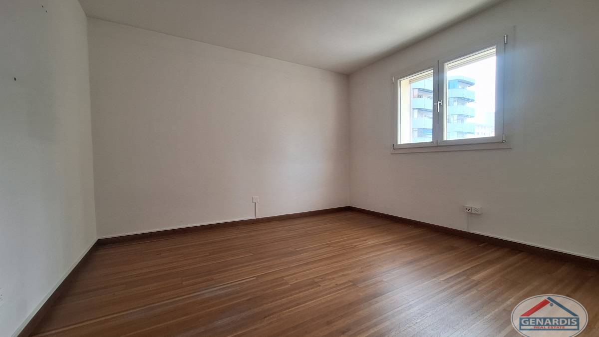 Leerer heller Wohnraum mit Holzoptik-Boden und Fenster