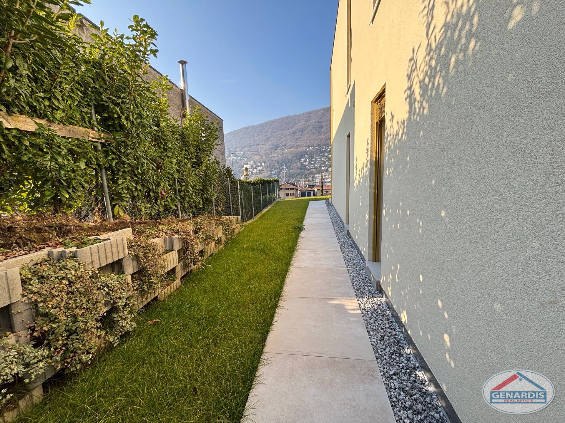 Seitlicher Garten- und Fassadenbereich mit Weg