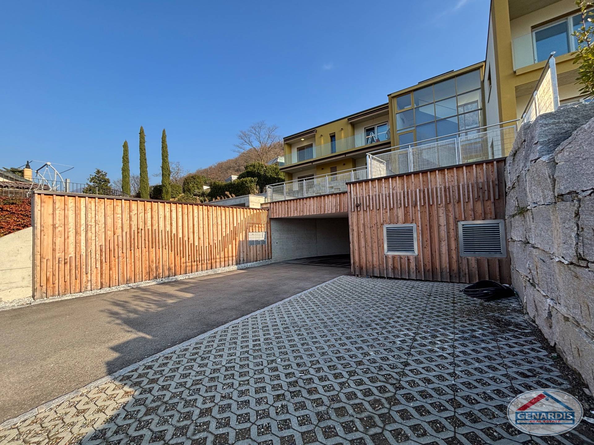 Moderne Zufahrt mit Holzfassade und Garage