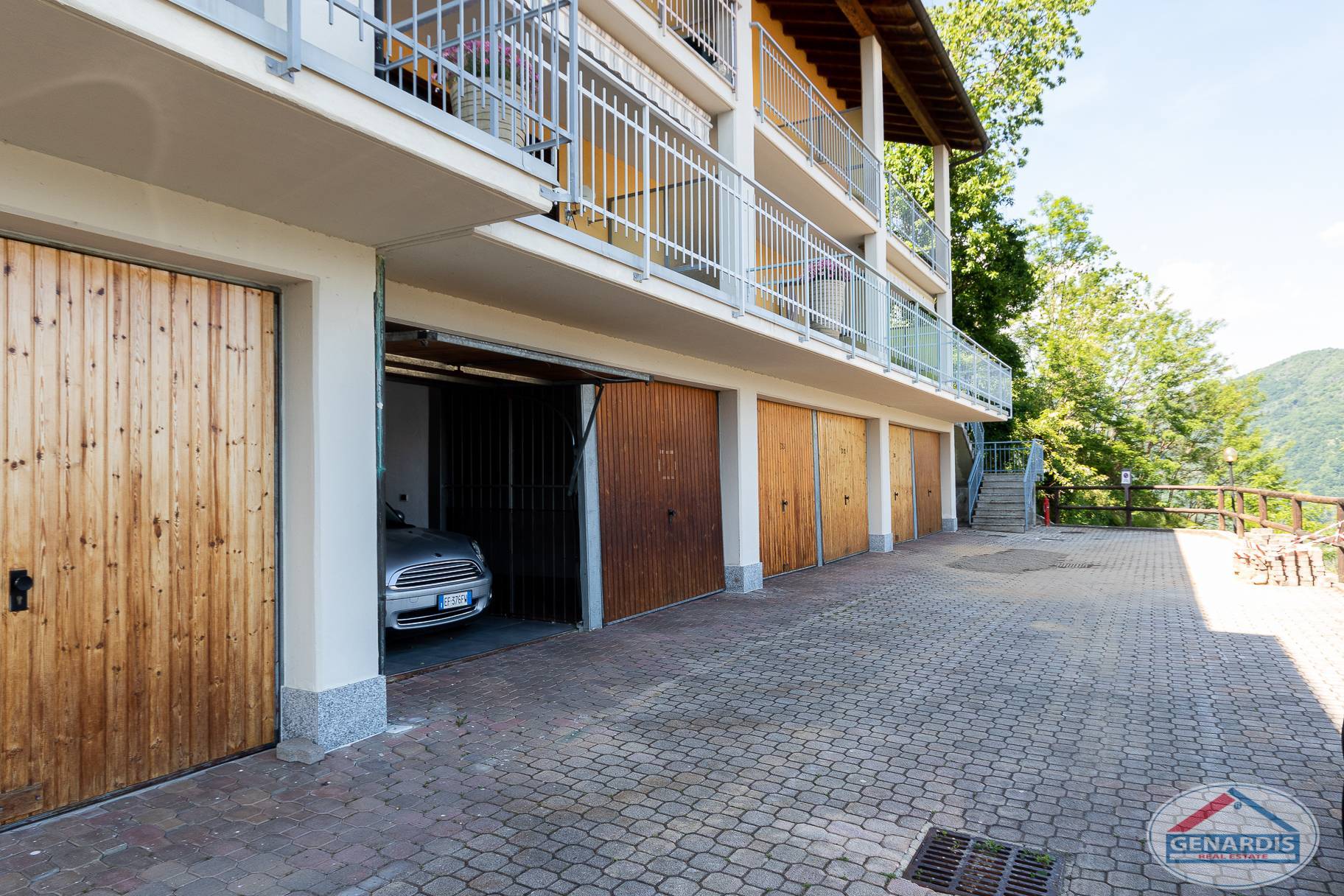 Außenansicht eines Mehrfamilienhauses mit Garagen und Balkonreihen