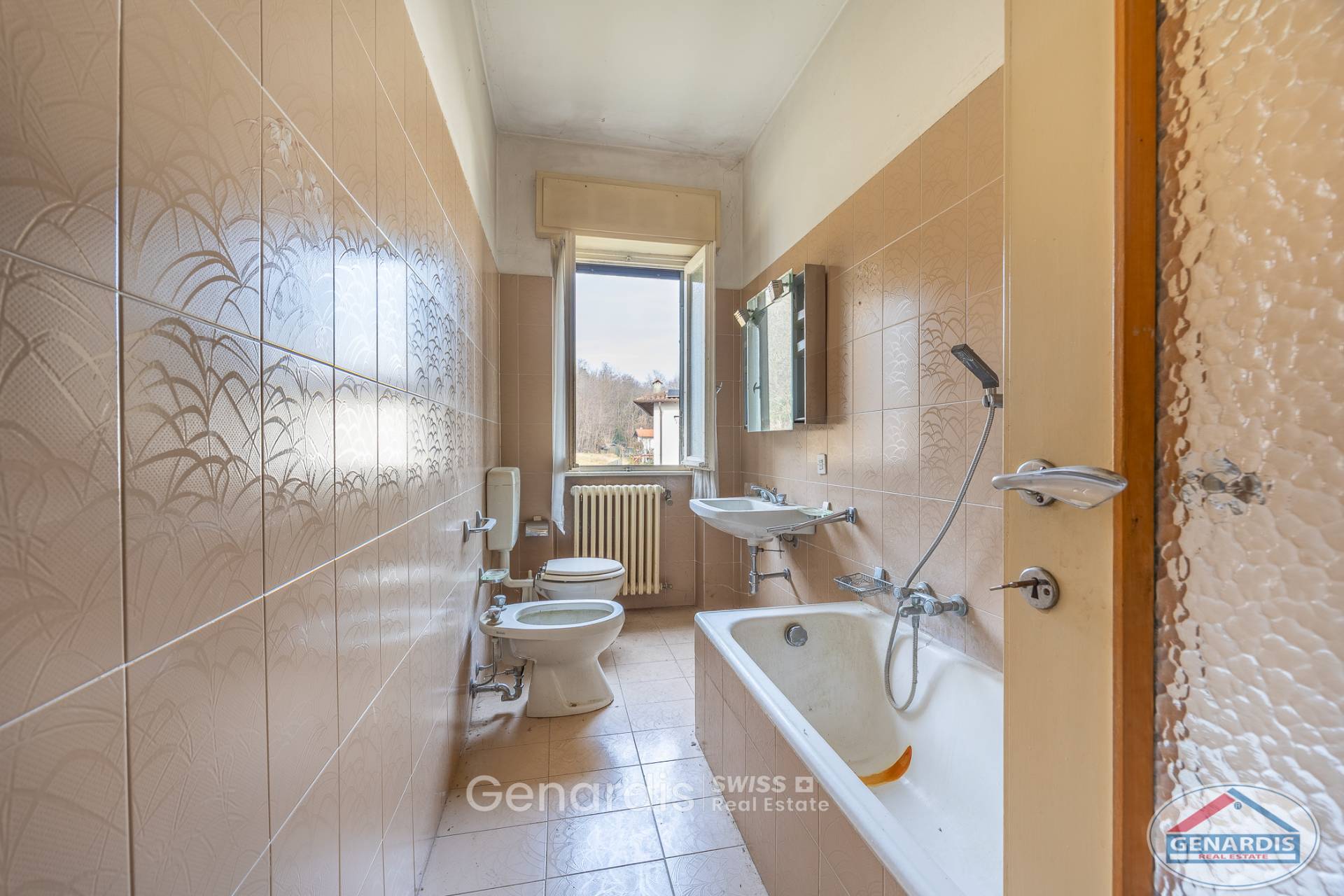 Längliches Badezimmer mit Badewanne, WC und Fenster