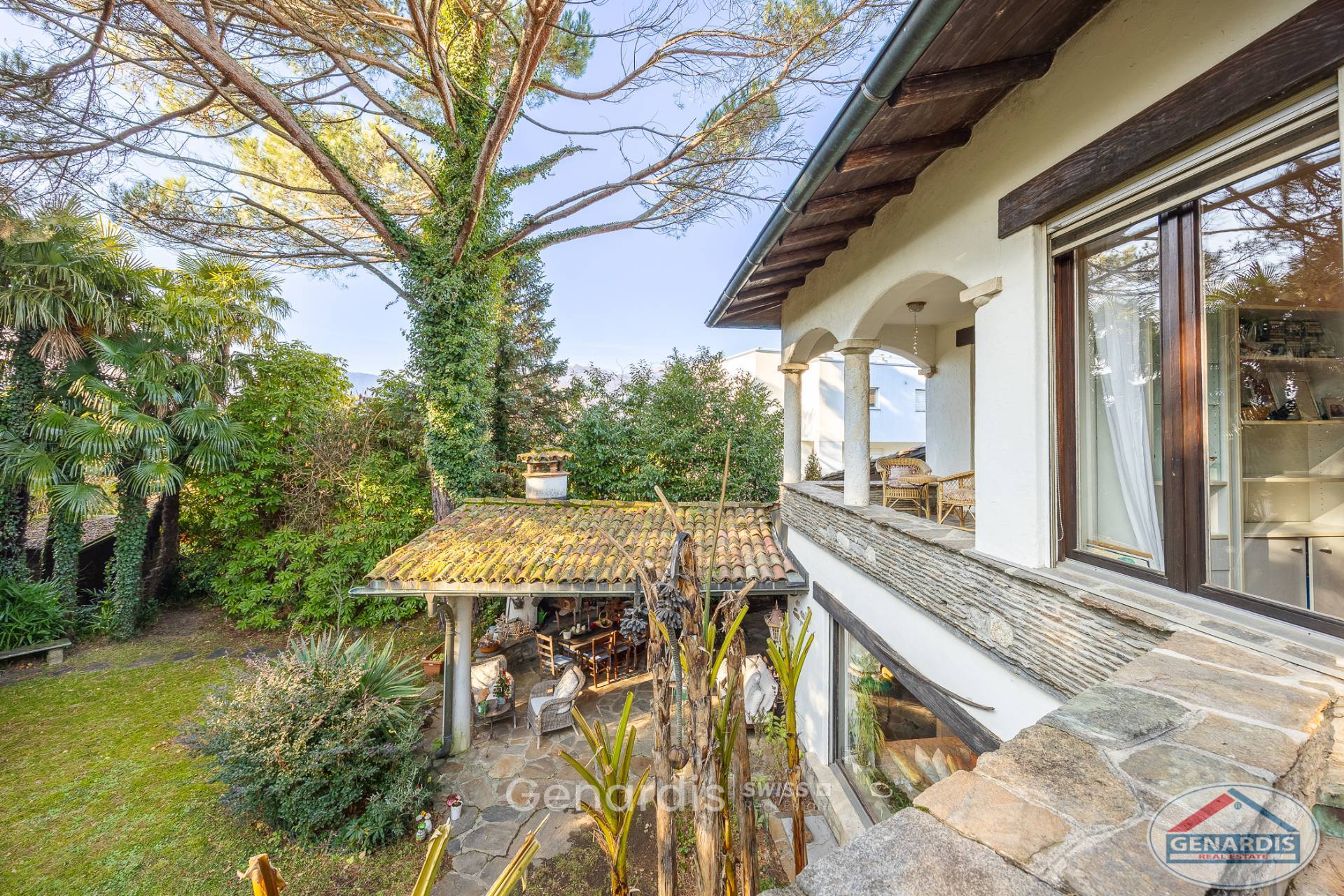 Haus mit mediterranem Garten und überdachter Terrasse