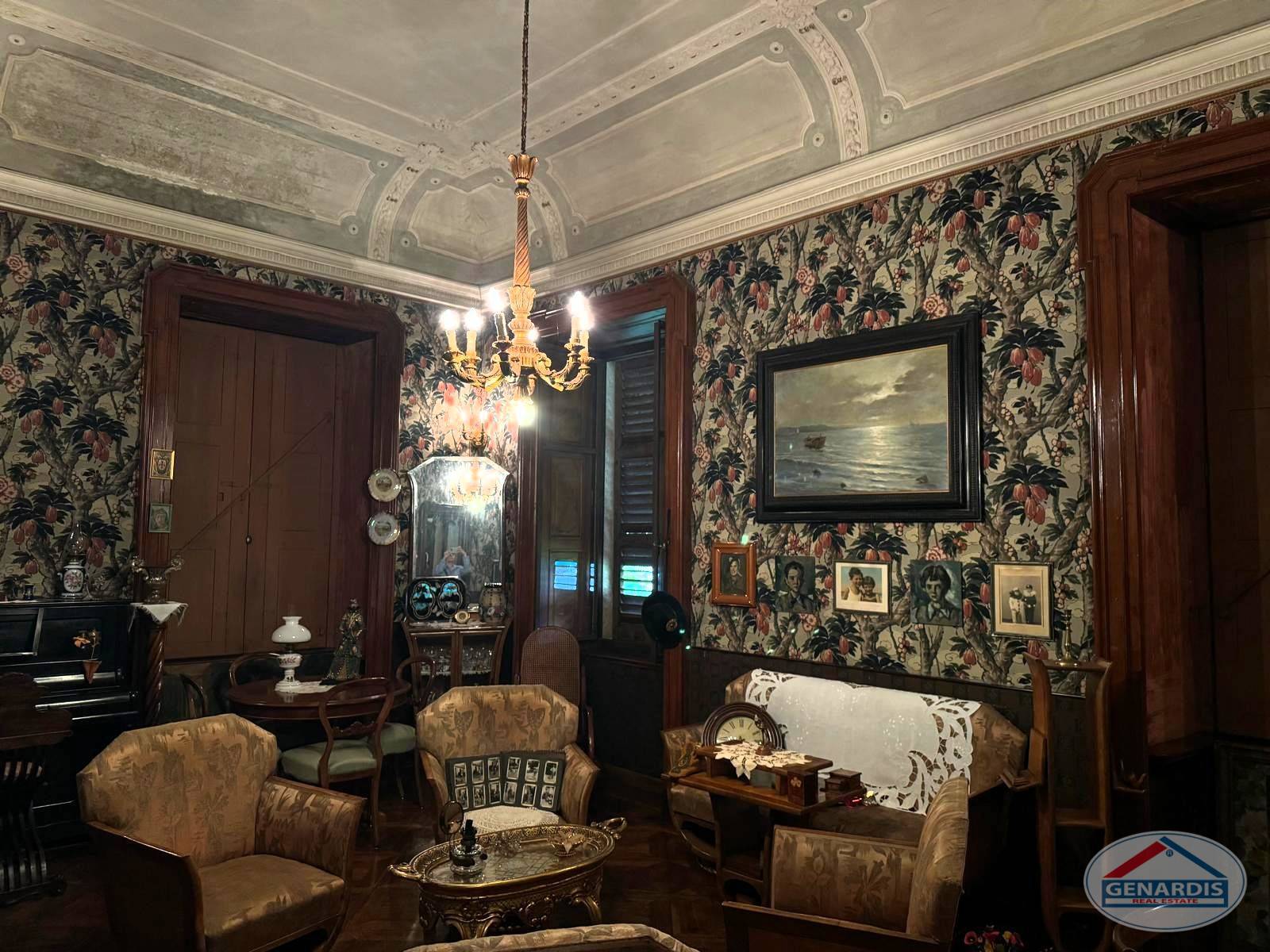 Klassischer Salon mit floraler Tapete und antikem Mobiliar