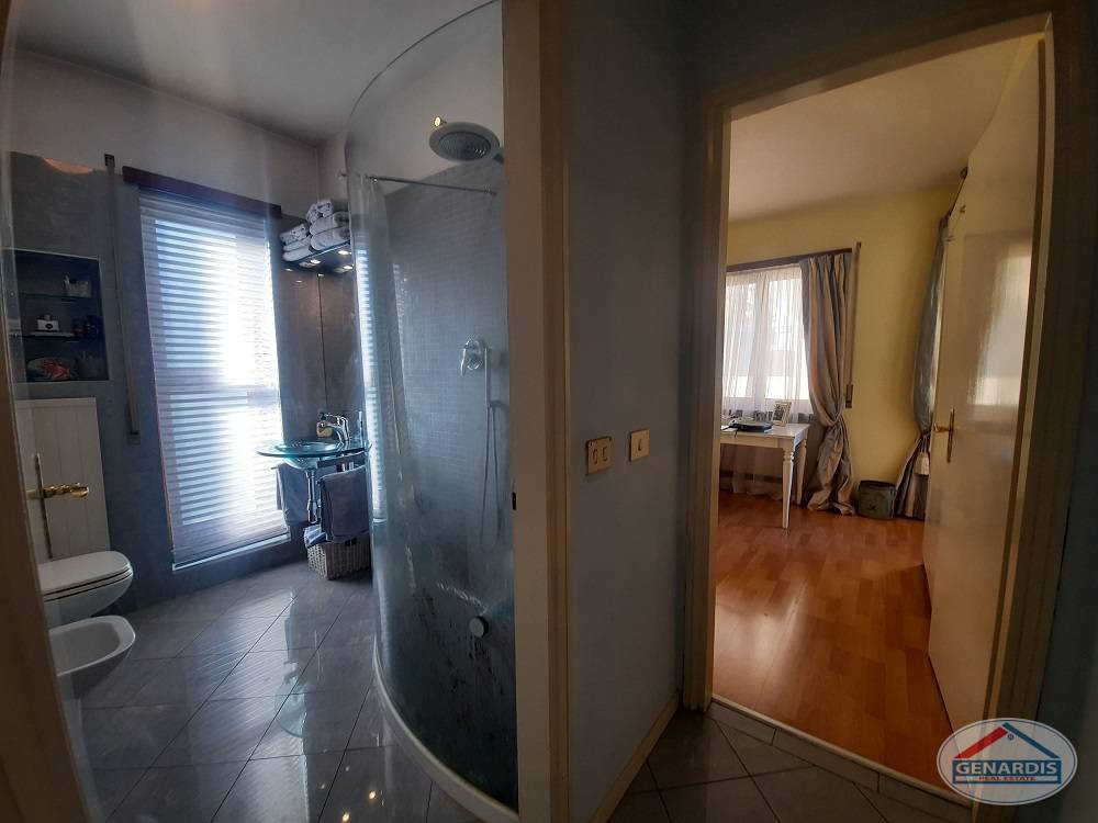 Blick von einem Flur in ein Badezimmer und ein angrenzendes Zimmer