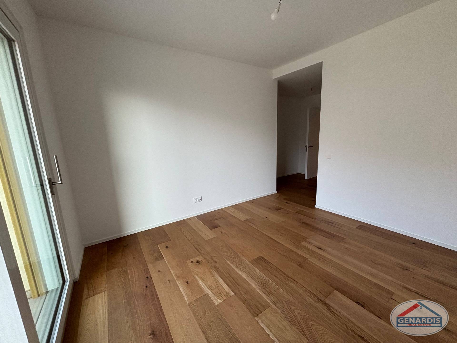 Leerer, frisch renovierter Raum mit Parkettboden