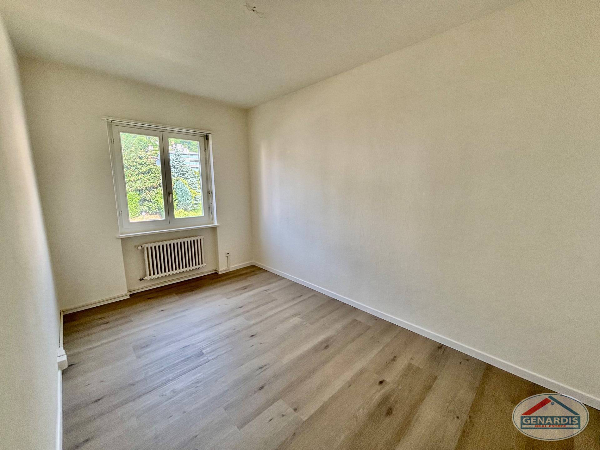 Leerer, frisch renovierter Raum mit Fenster und Heizkörper