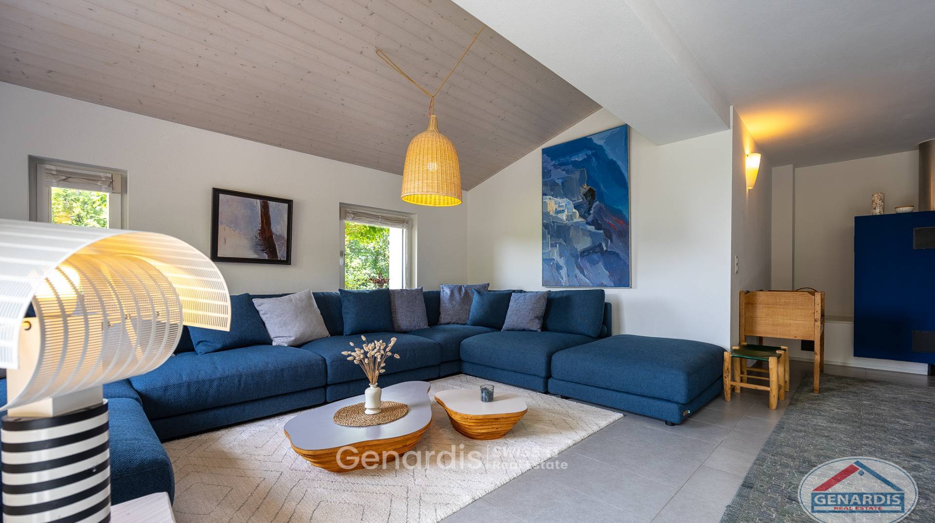Modernes Wohnzimmer mit blauem Ecksofa und Holzdecke