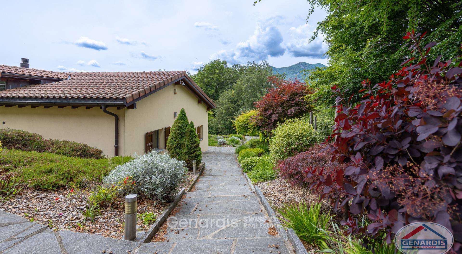 Außenansicht eines gepflegten Hauses mit Gartenweg