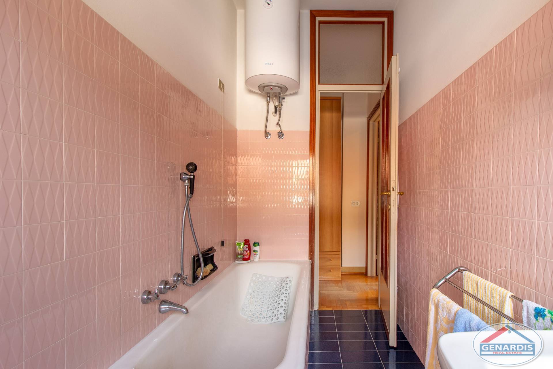 Kleines Bad mit Wanne und pinken Fliesen