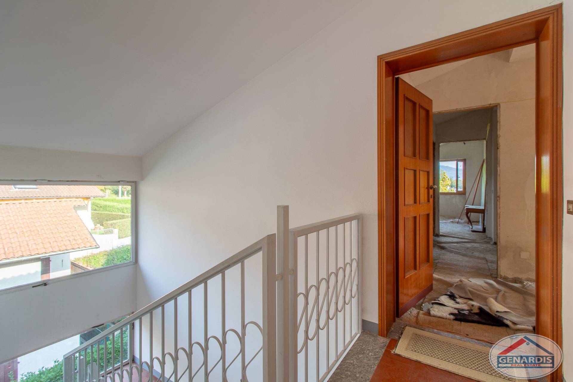 Treppenhaus mit offenem Blick in einen renovierungsbedürftigen Bereich