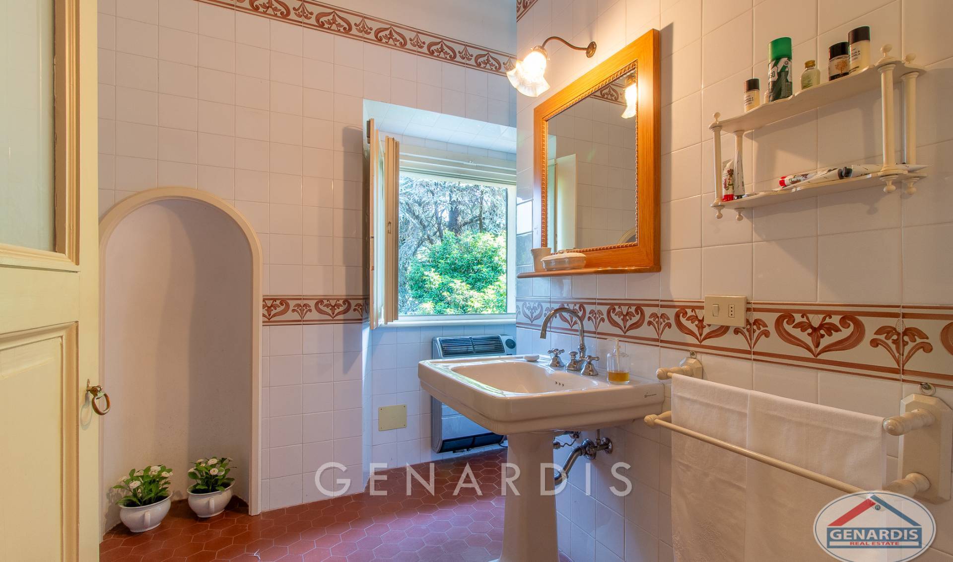Badezimmer mit Fliesen, Fenster und klassischem Waschplatz