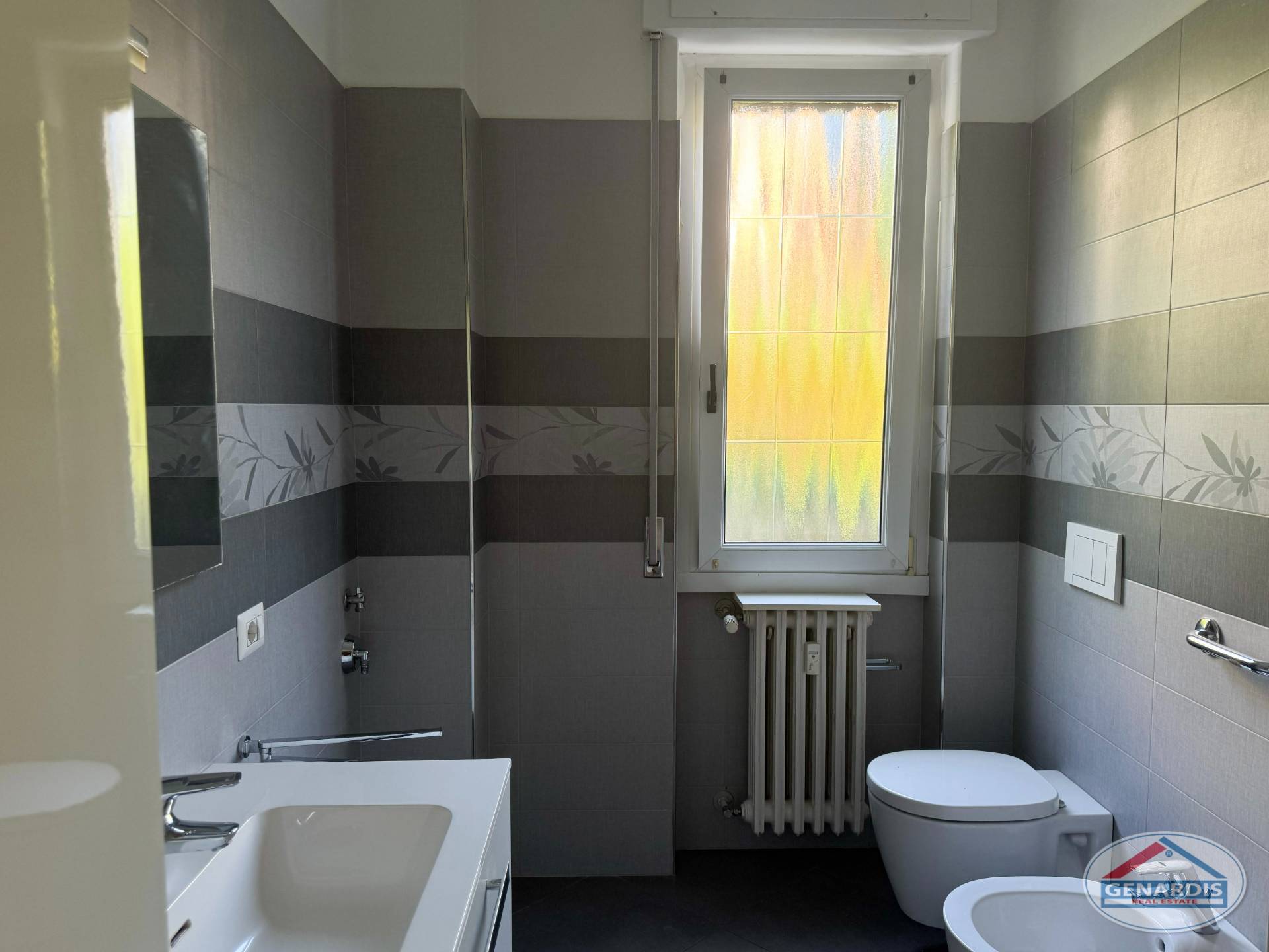 Modernes Bad mit grauen Fliesen und Fenster