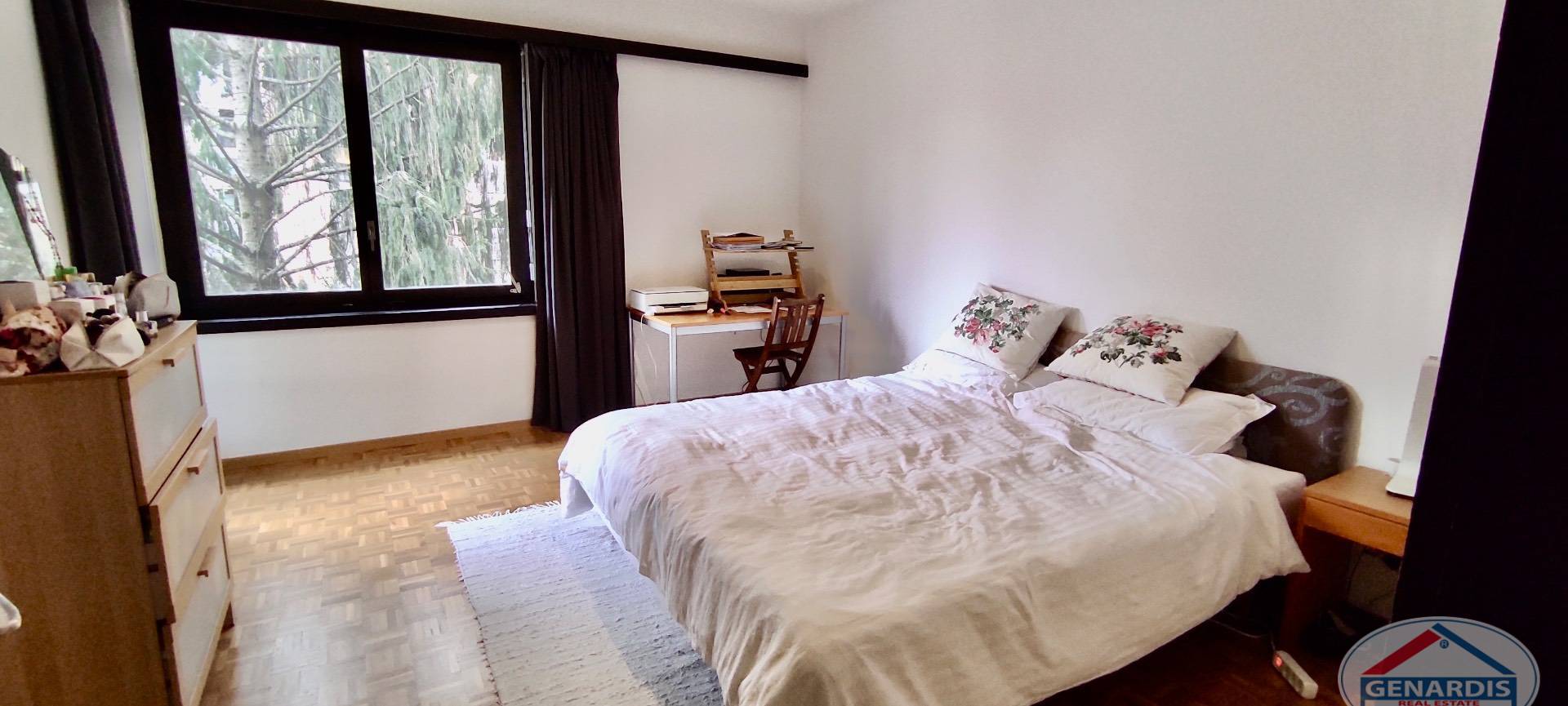 Helles Schlafzimmer mit großem Fenster und Doppelbett