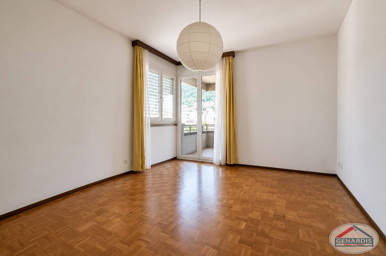 Leeres Zimmer mit Balkon und Parkettboden