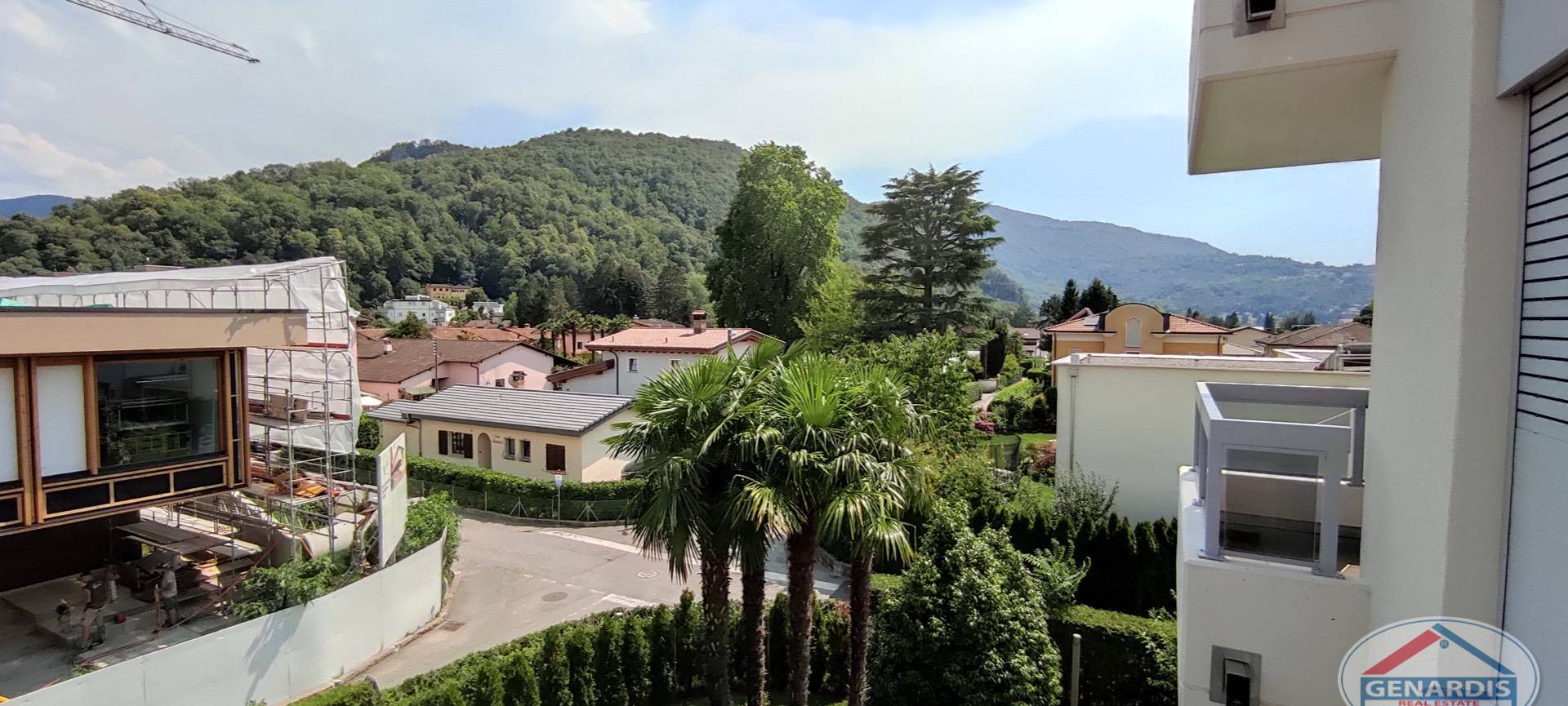 Blick vom Balkon auf Wohnhäuser und Berge