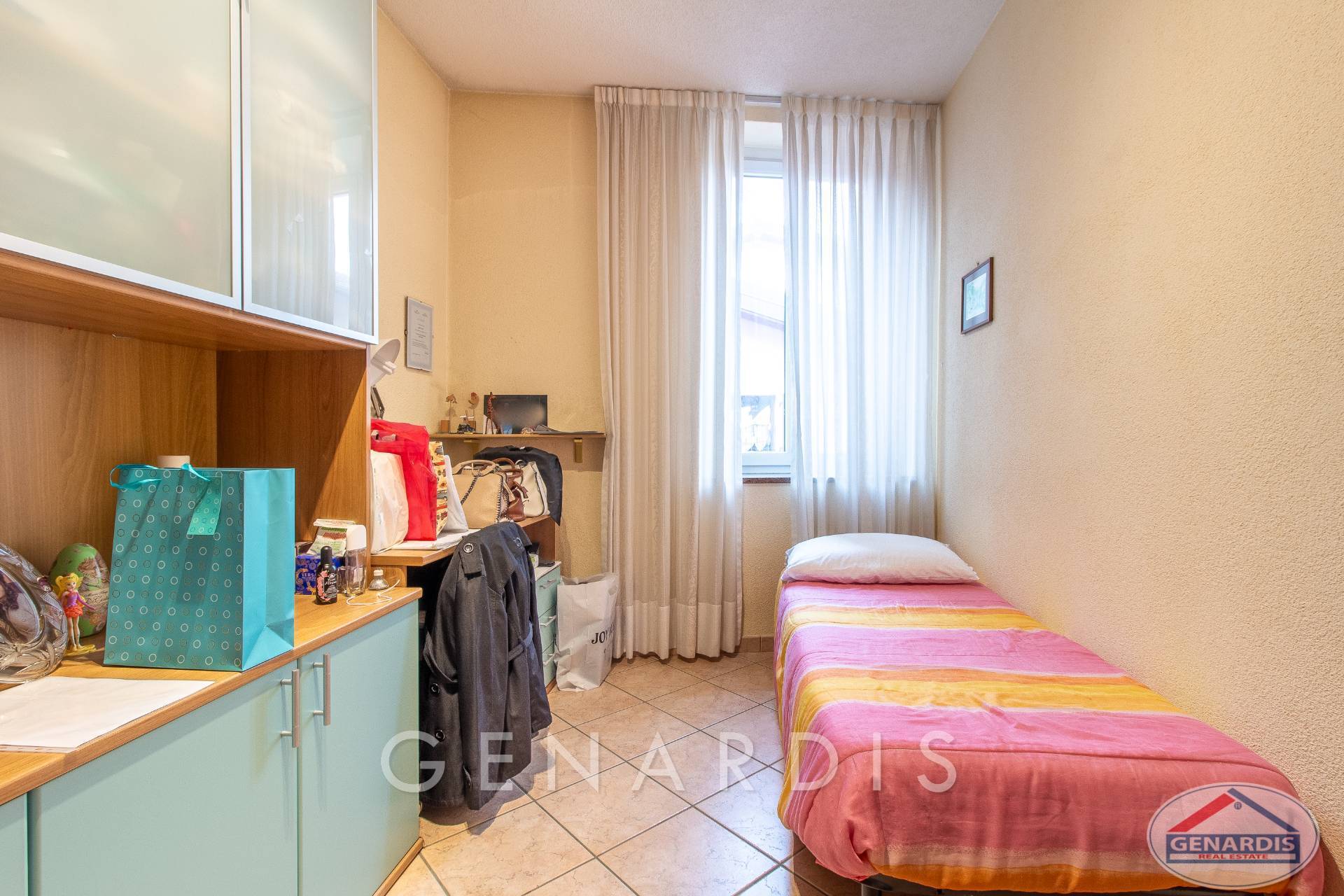 Kleines, helles Schlafzimmer mit Bett und Stauraum