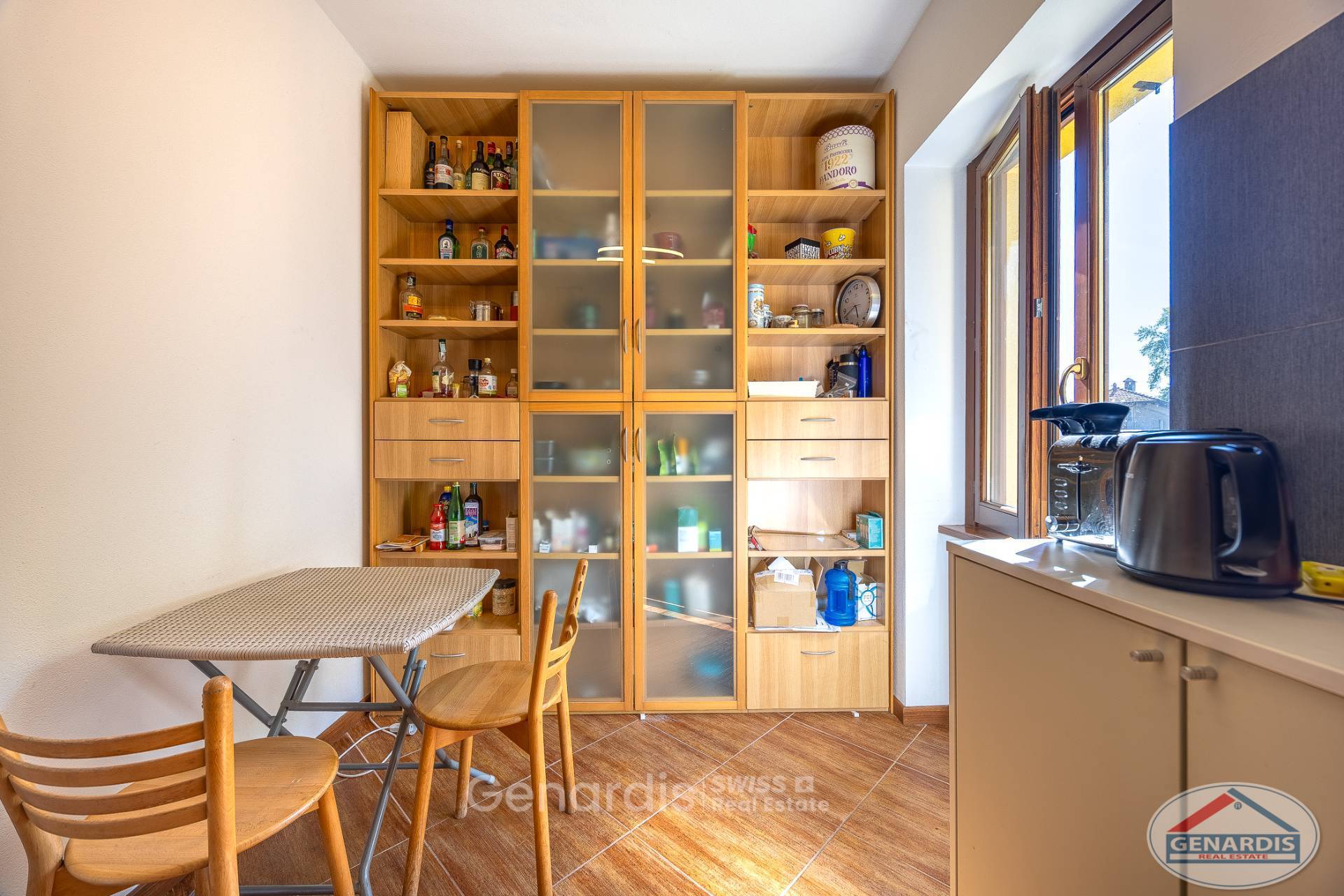 Kleine Ess- bzw. Küchenzone mit Vitrinenschrank und Fenster