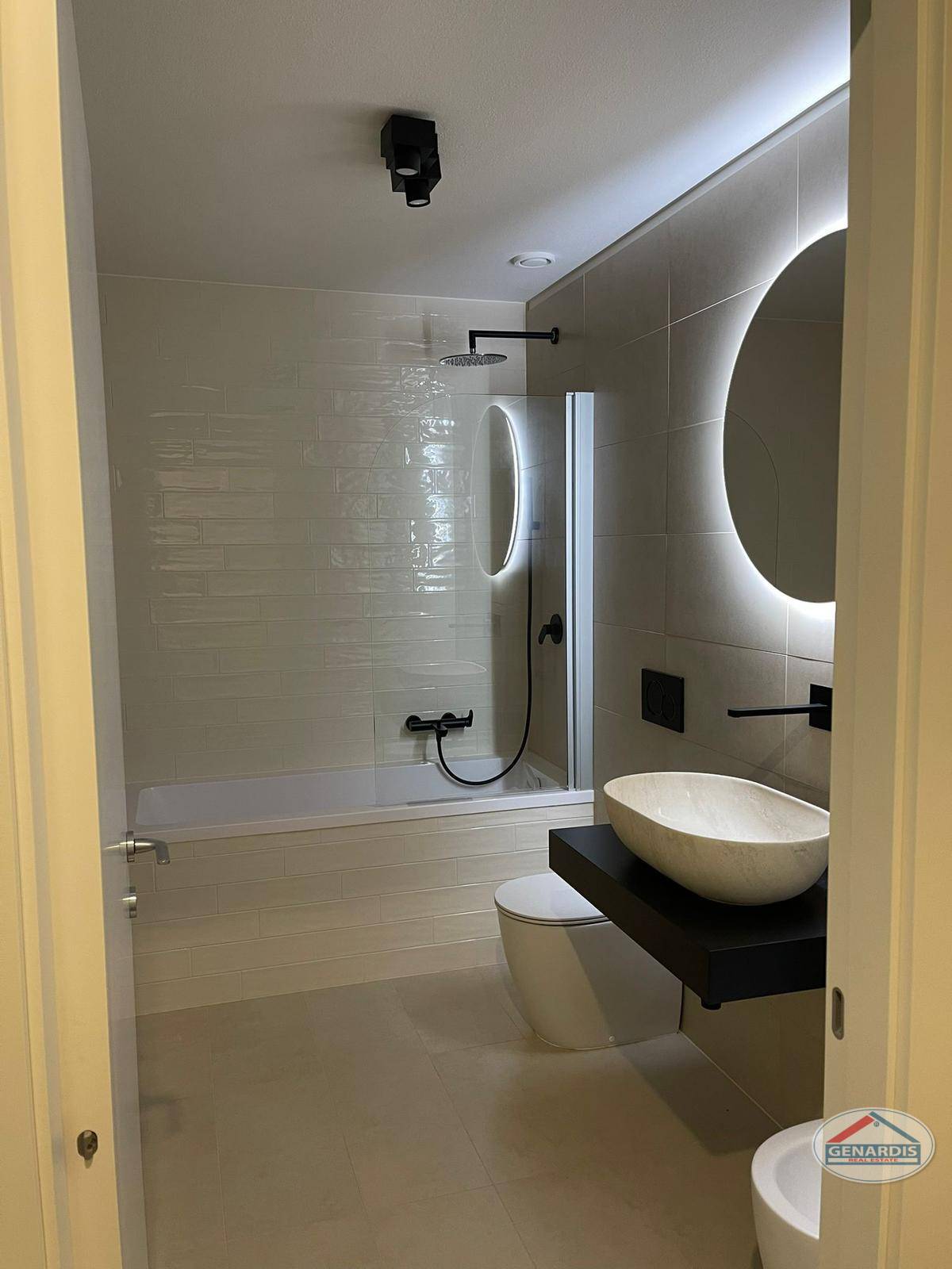 Modernes Bad mit Walk-in-Badewanne und beleuchtetem Spiegel