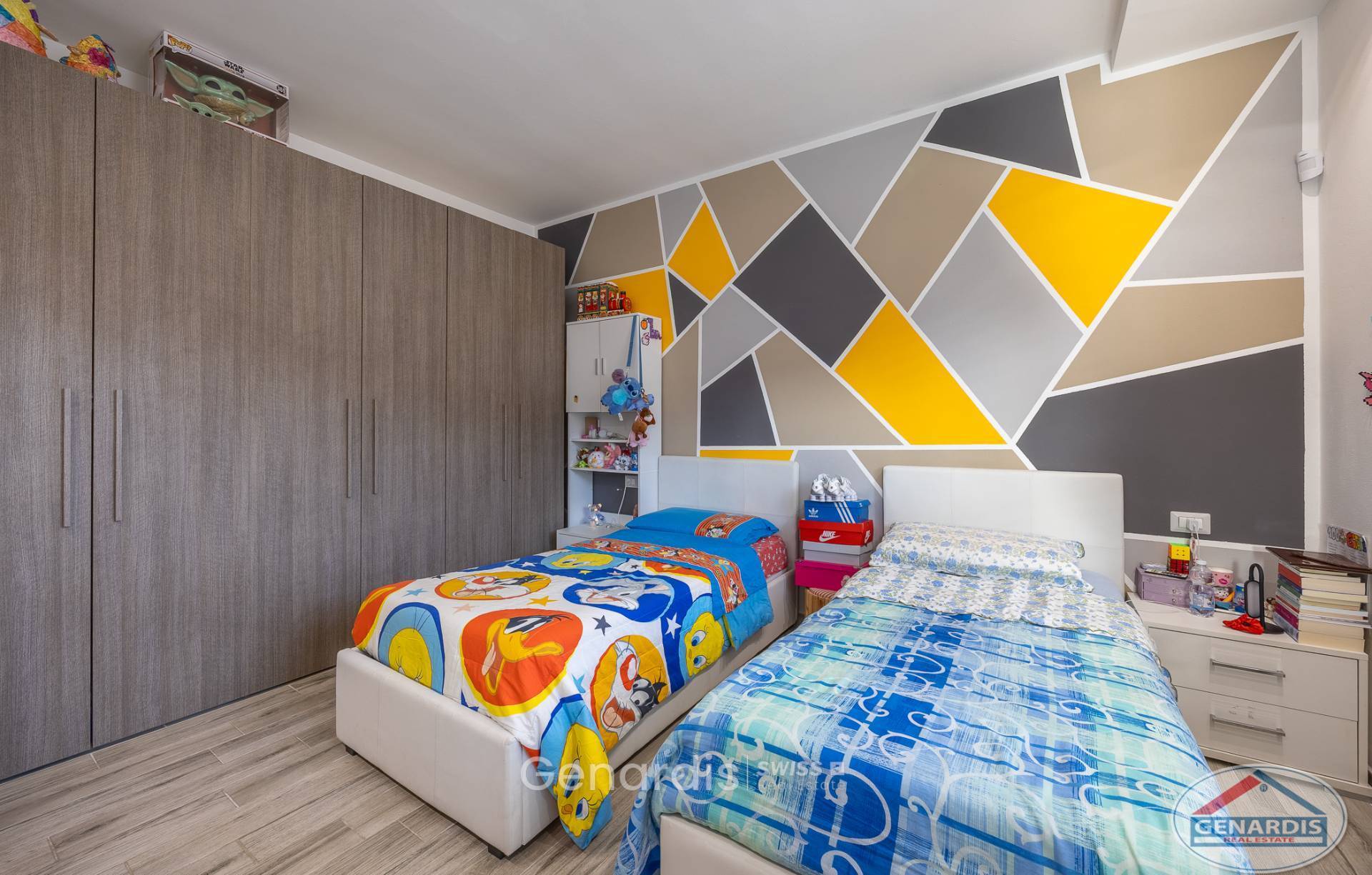 Kinderzimmer mit zwei Betten und geometrischer Akzentwand
