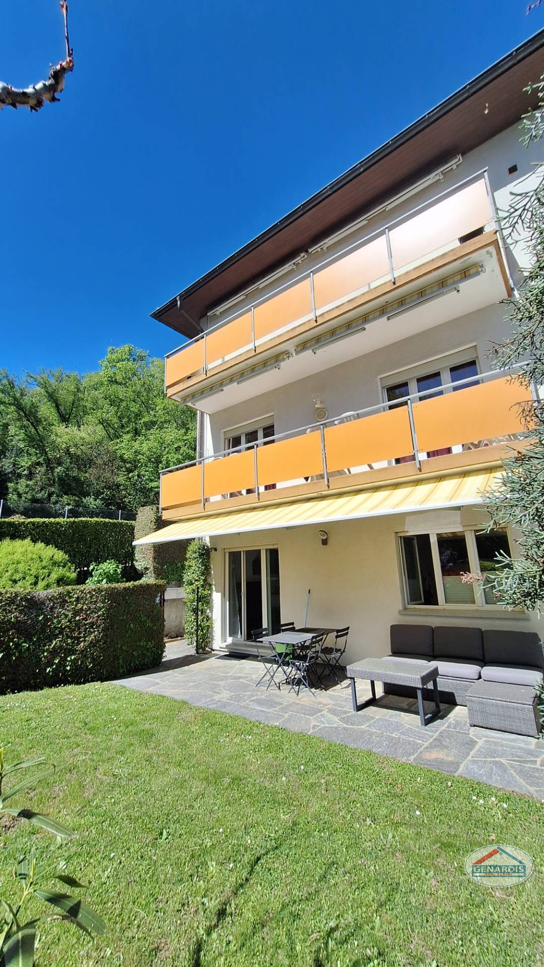 Gartenansicht eines Mehrfamilienhauses mit Terrasse