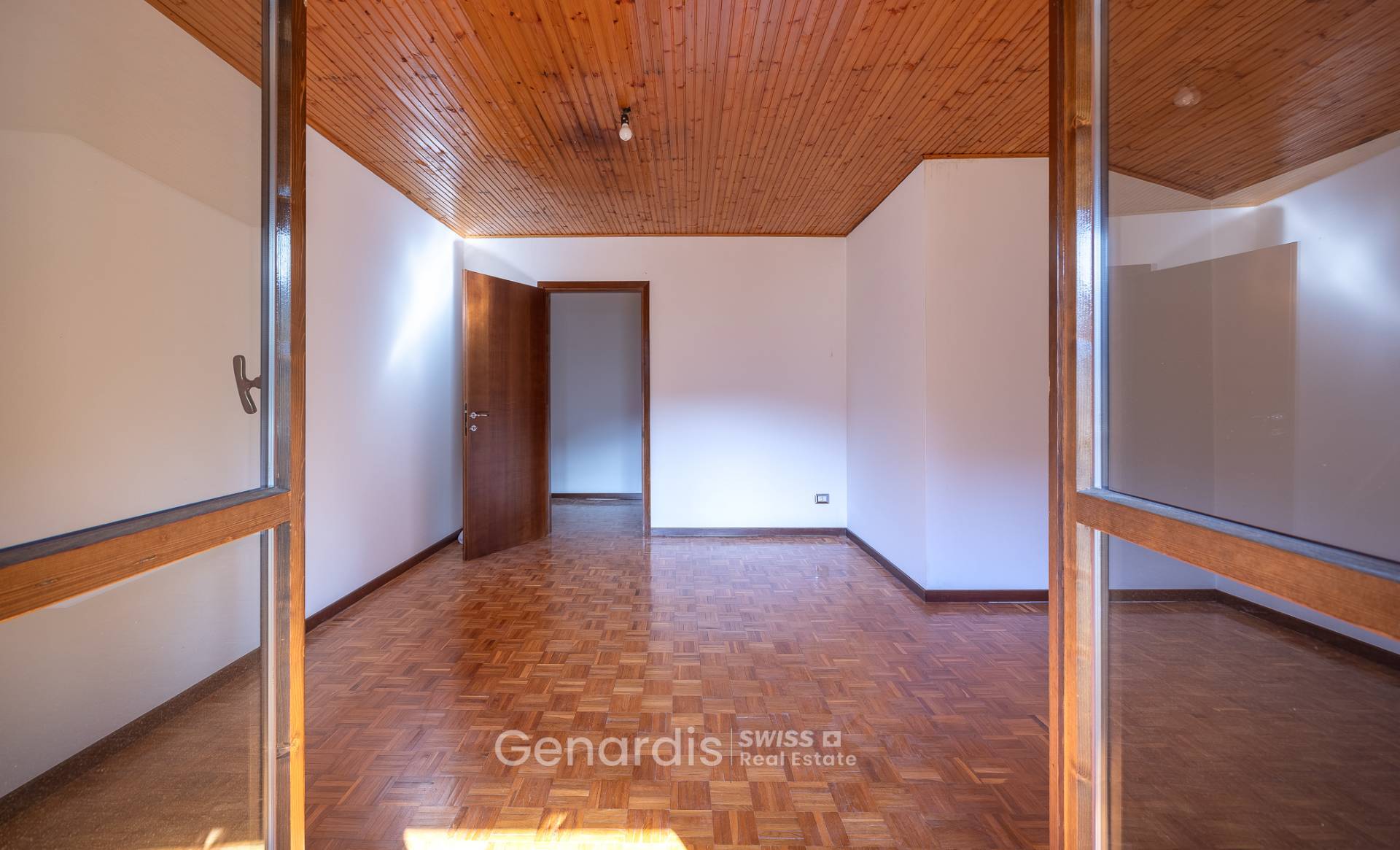 Leerer Innenraum mit Holzdecke und Parkettboden