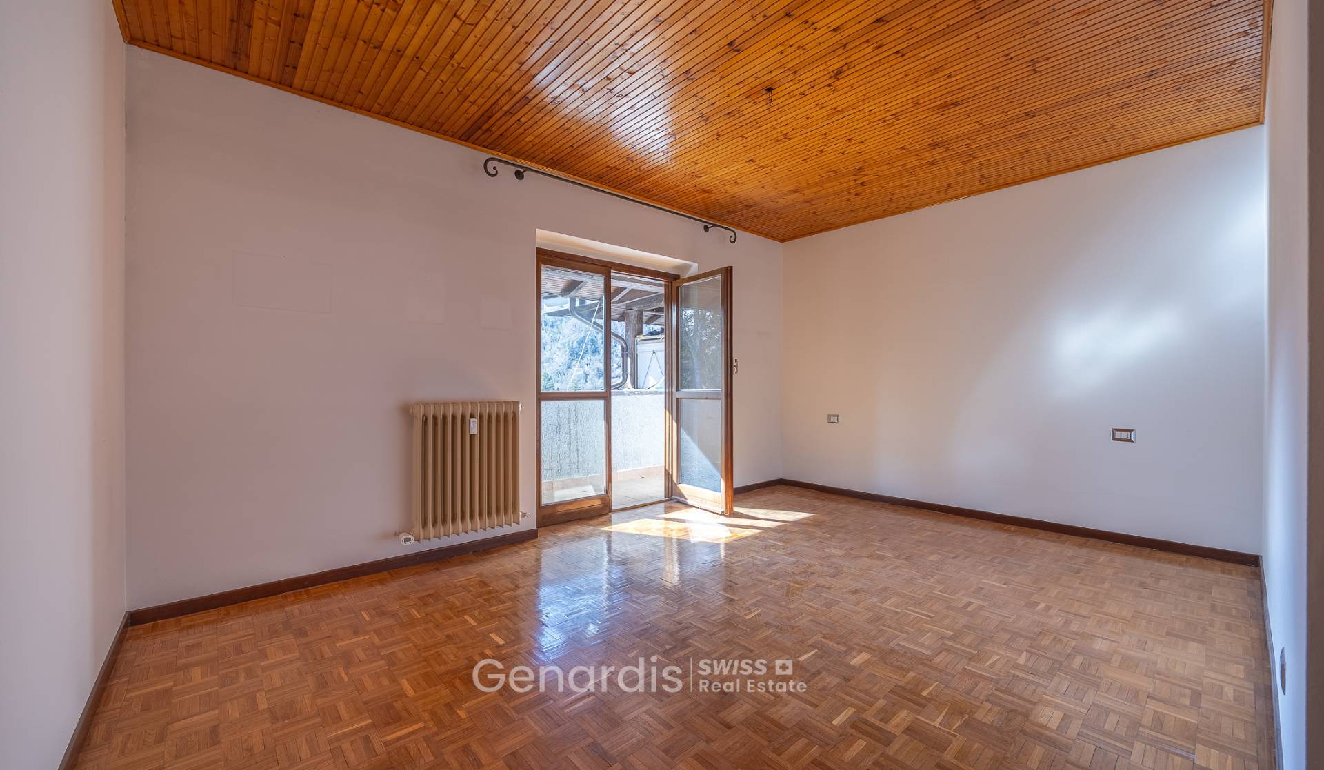 Leerer Raum mit Holzdecke und Parkettboden