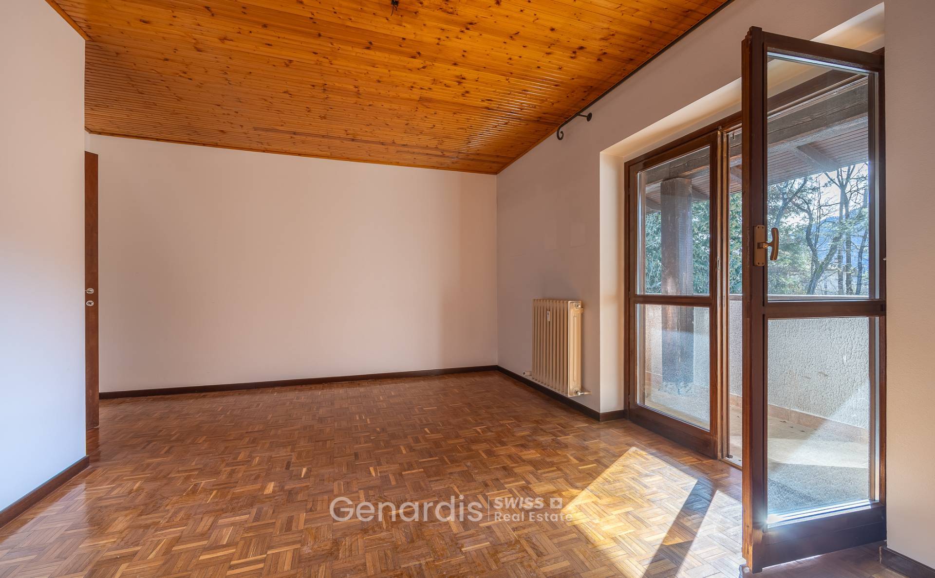 Leerer Wohnraum mit Parkett und Holzdecke