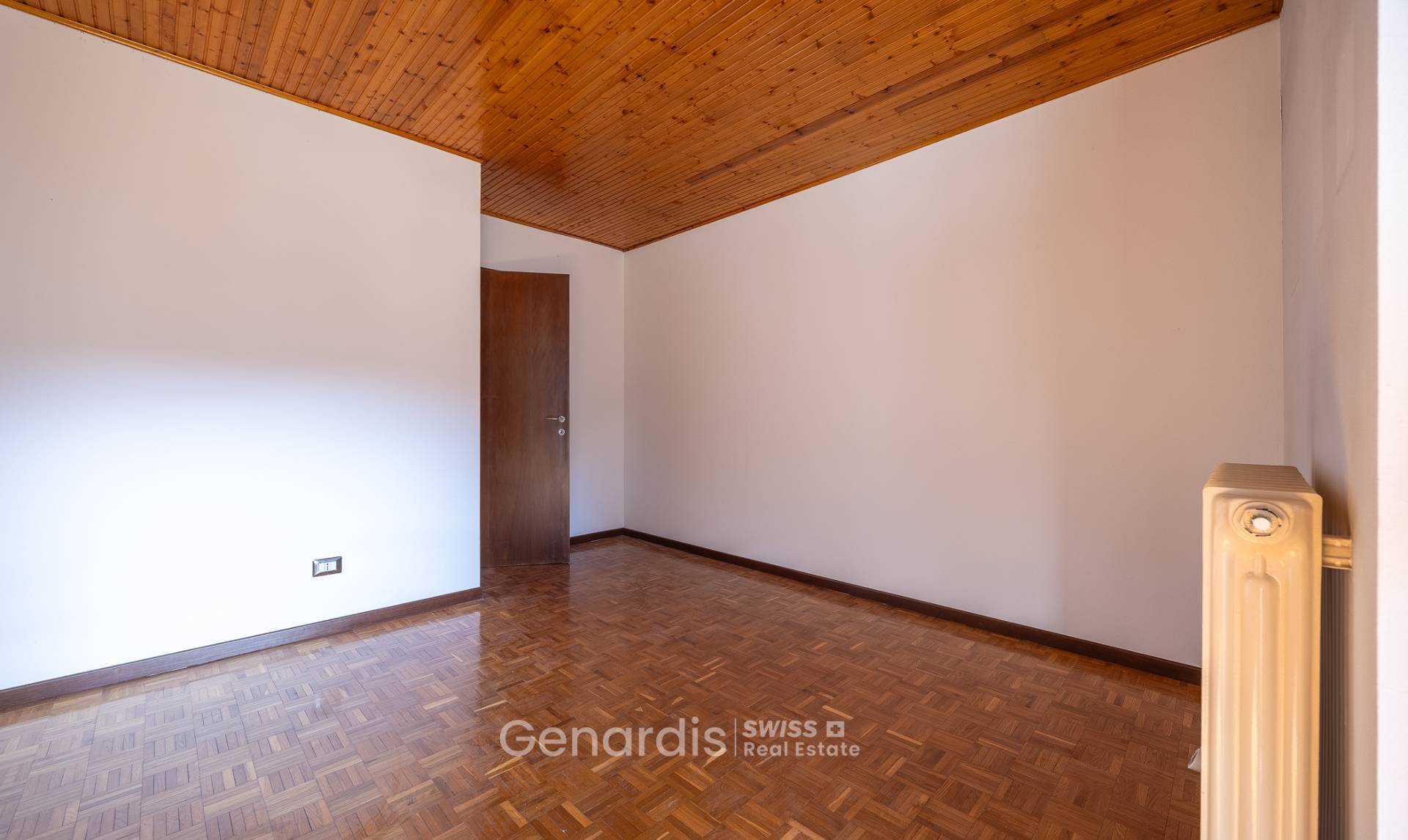 Leerer Raum mit Holzdecke und Parkettboden
