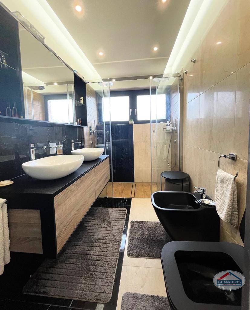 Modernes Badezimmer mit Doppelwaschtisch und Glasdusche