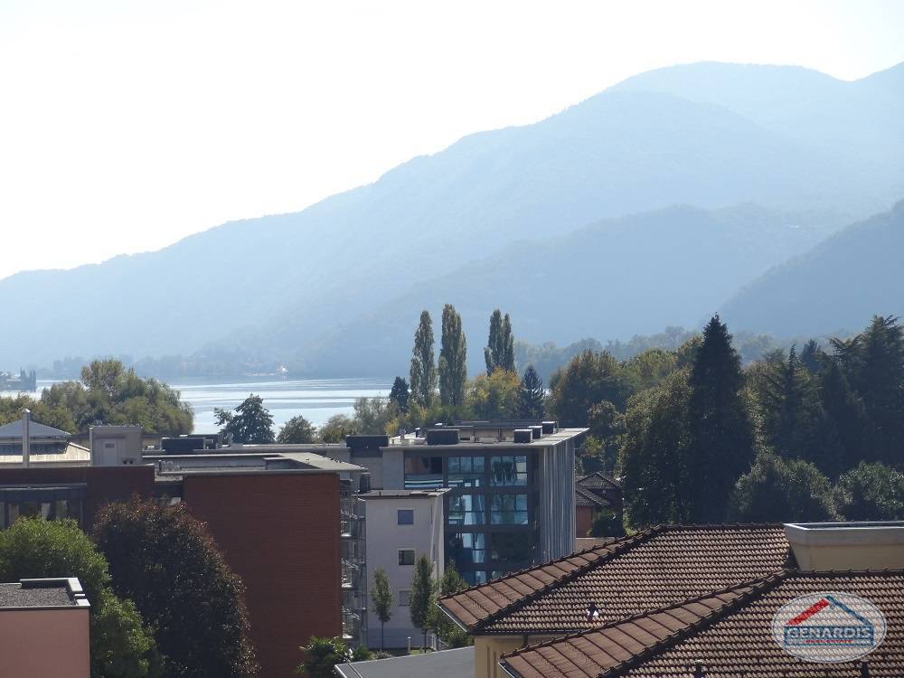 Seeblick mit Bergen und Wohnhäusern