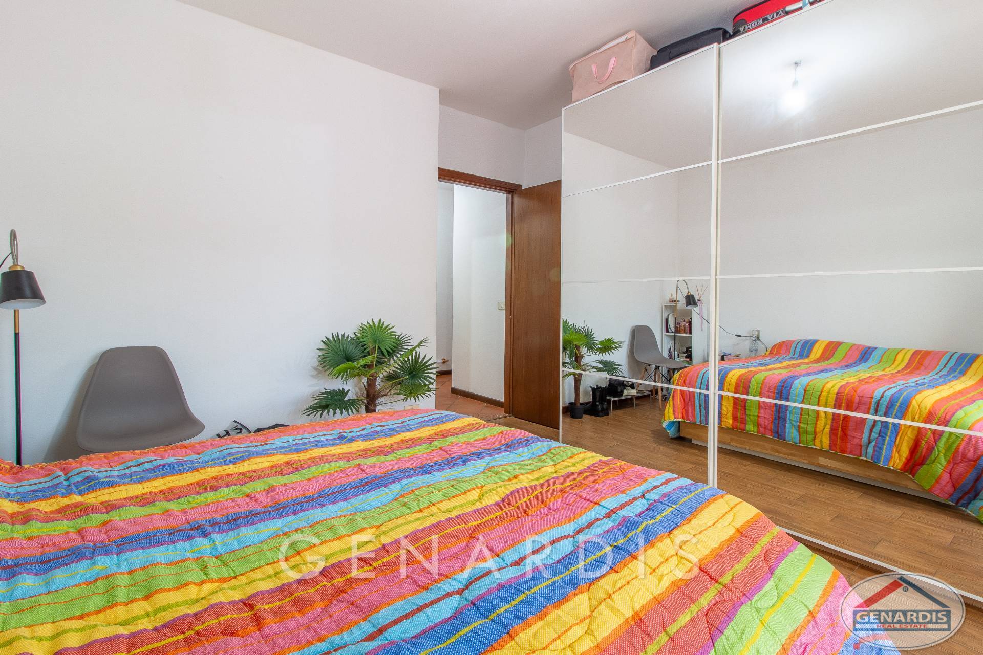 Helles Schlafzimmer mit Regenbogen-Bettdecke