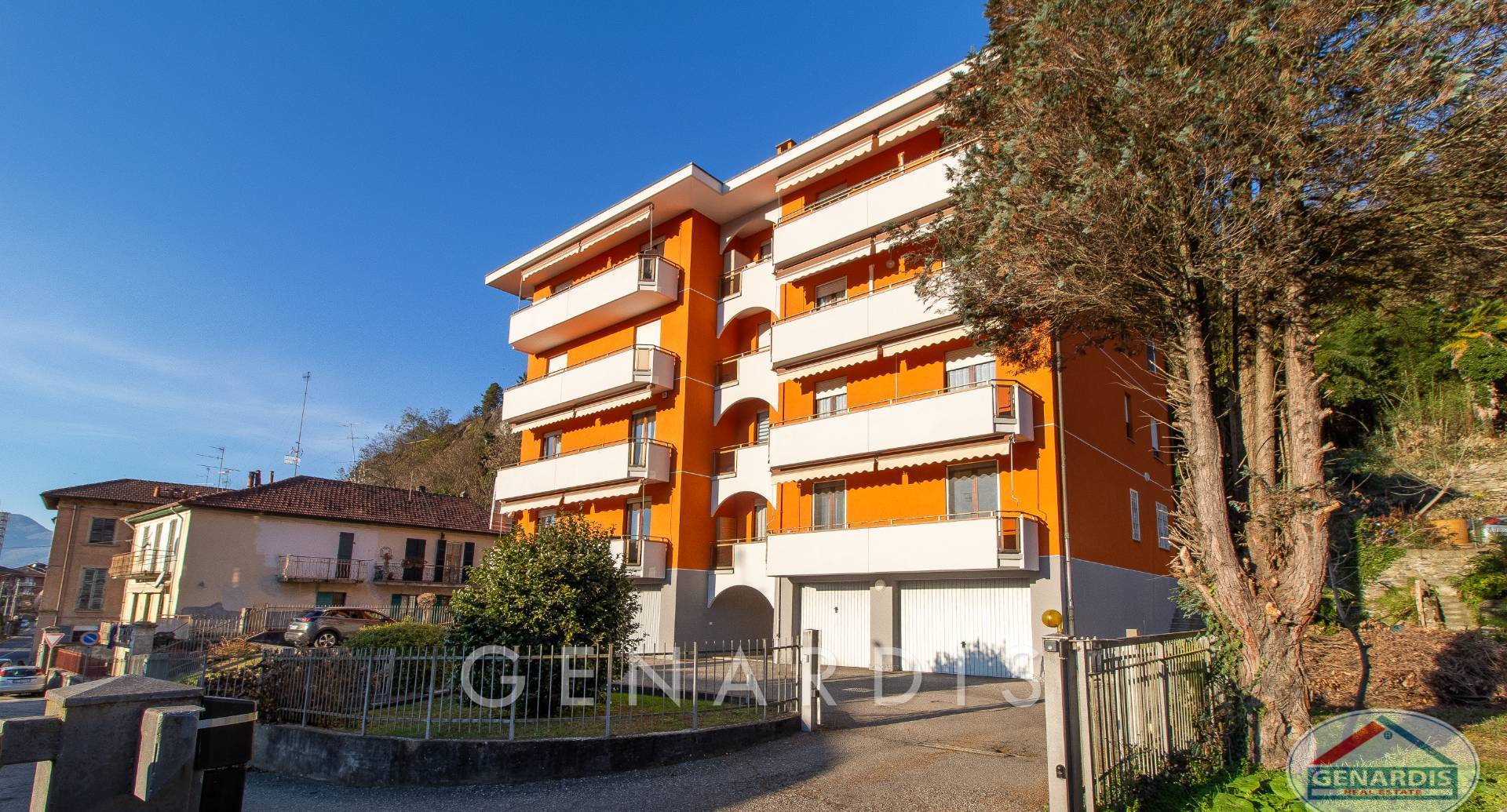 Mehrfamilienhaus mit orangefarbener Fassade und Balkonen