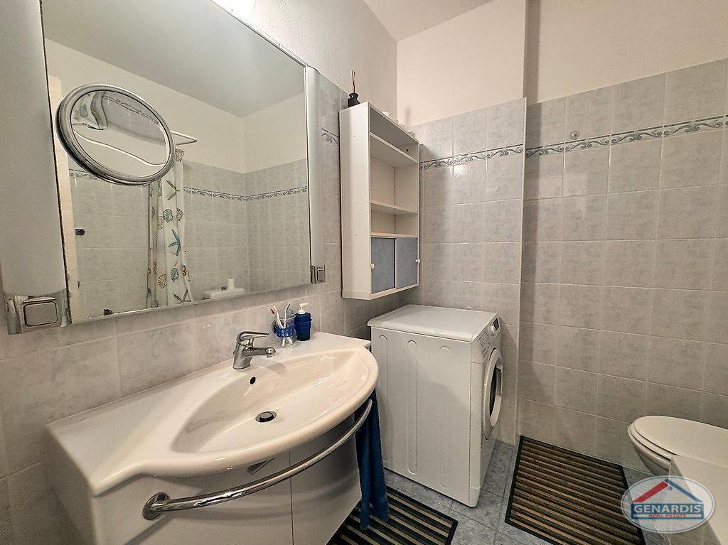Badezimmer mit Waschmaschine und Waschbecken