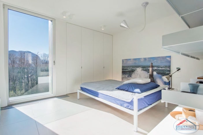 Helles Schlafzimmer mit großem Fenster und Bergblick
