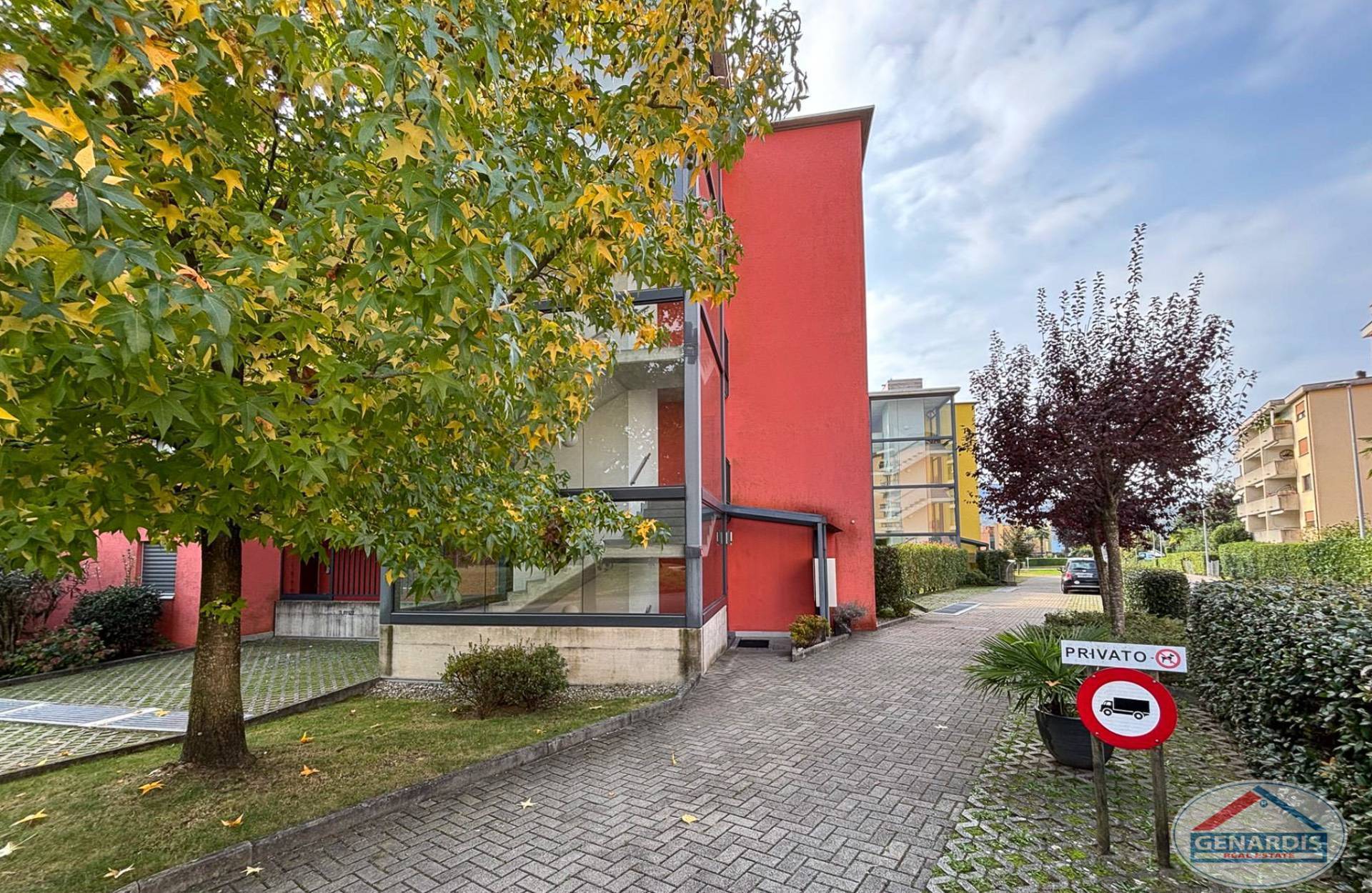 Rotes modernes Wohngebäude mit begrüntem Umfeld