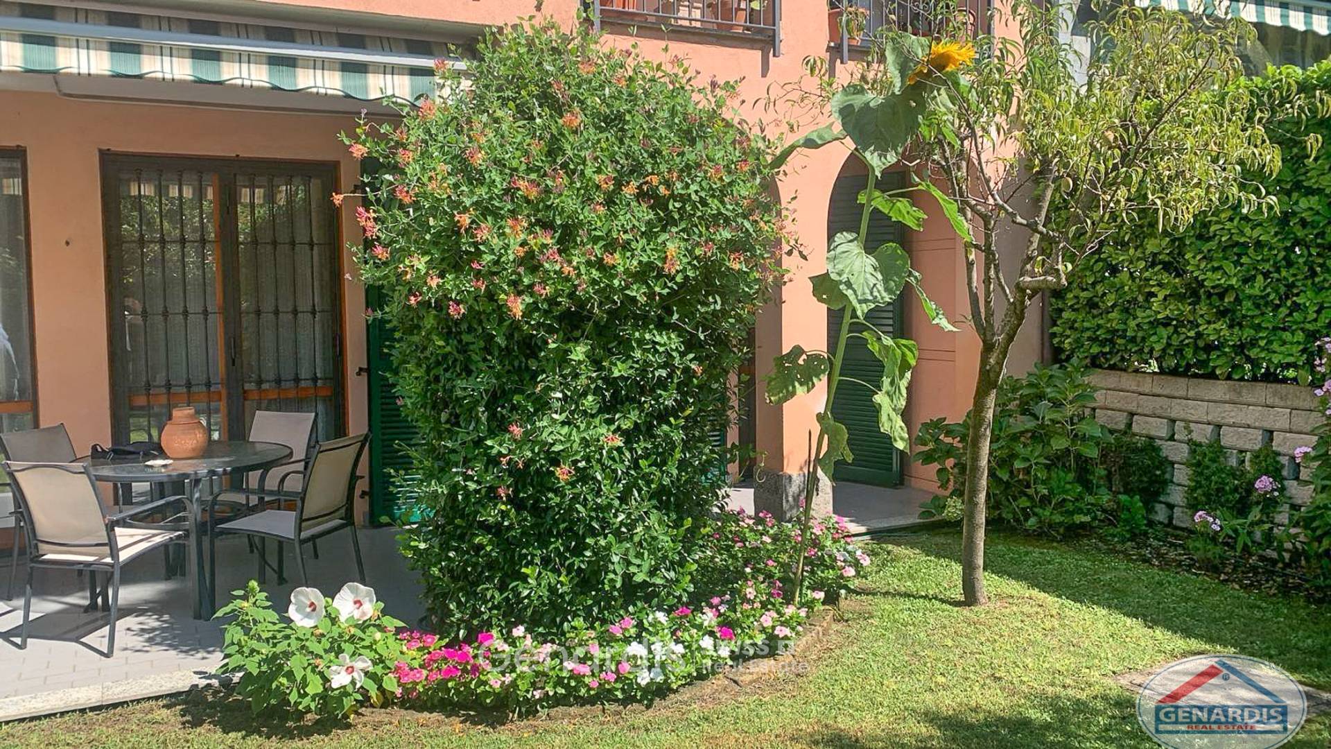 Sonnige Garten-/Terrassenansicht eines Wohnhauses