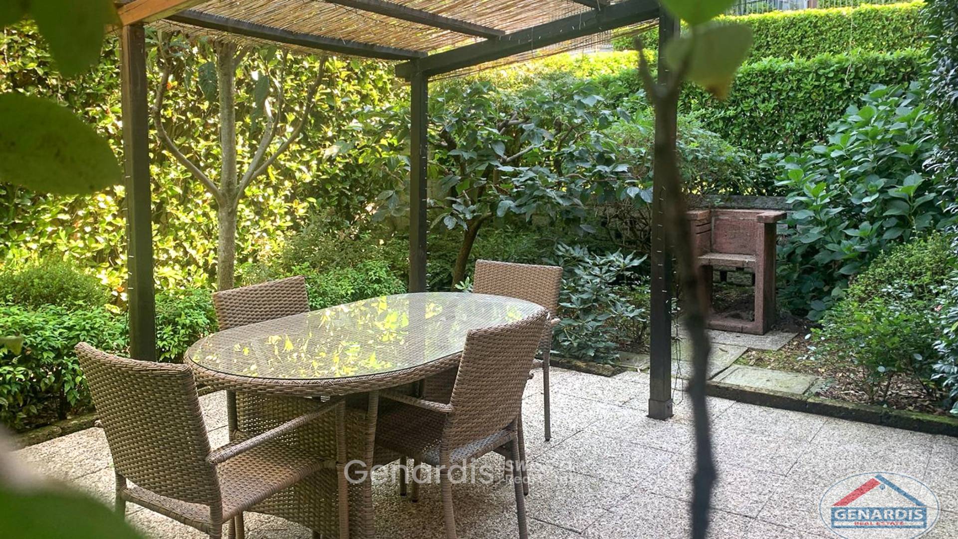 Überdachte Gartenlounge mit Esstisch