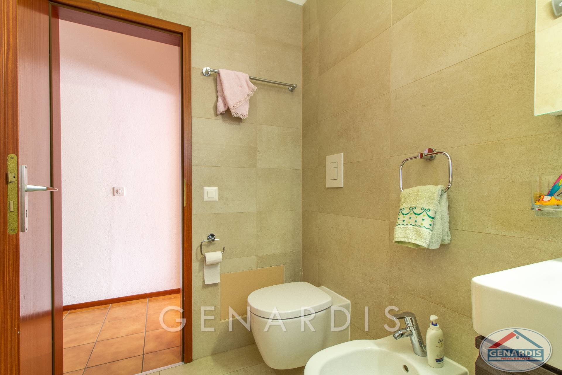 Gäste-WC mit beige gefliesten Wänden