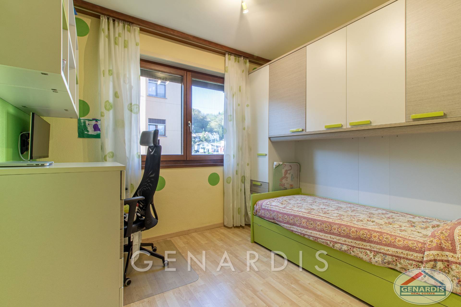 Kleines Kinderzimmer mit Bett und Schreibtisch