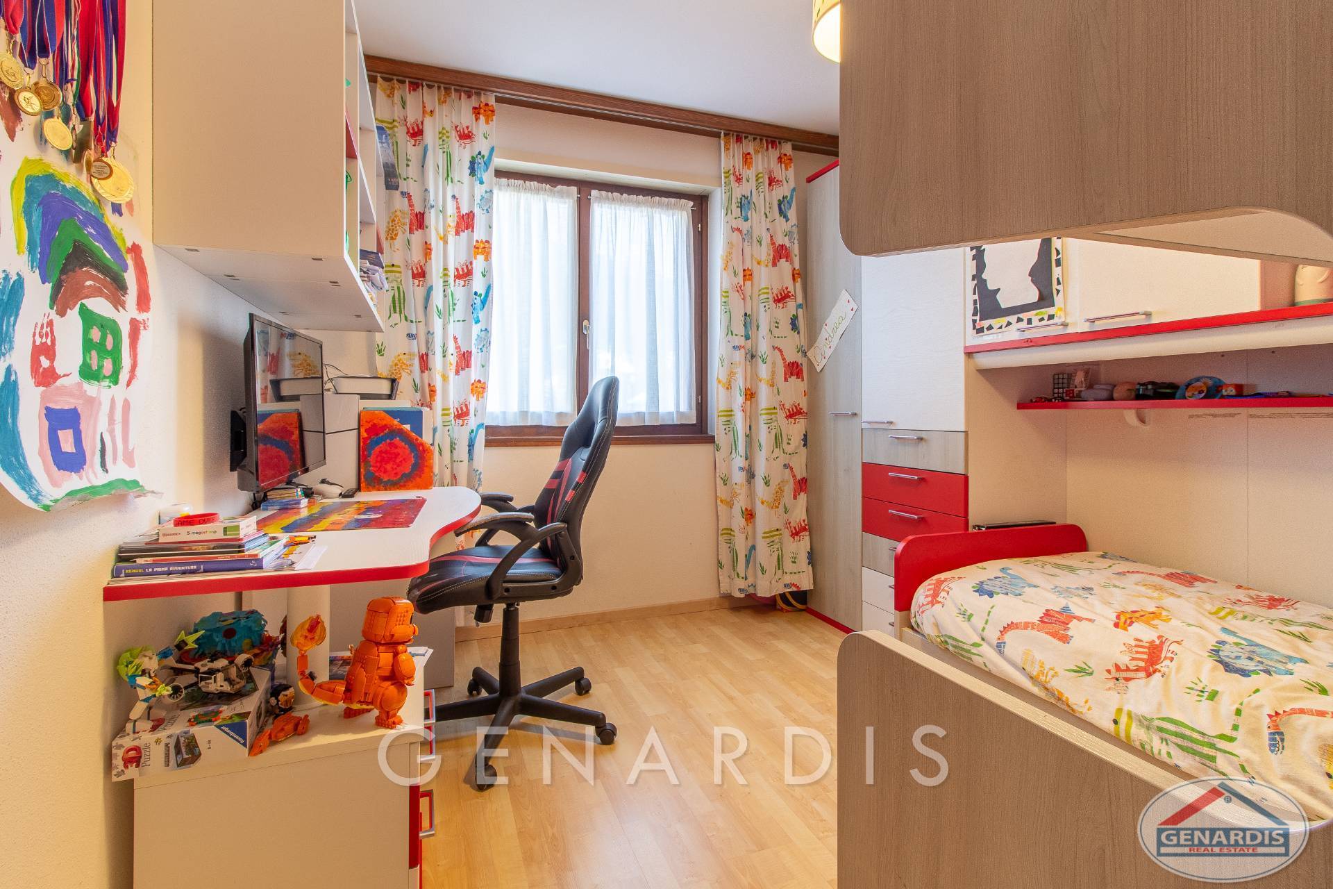 Kinderzimmer mit Schreibtisch und Bett