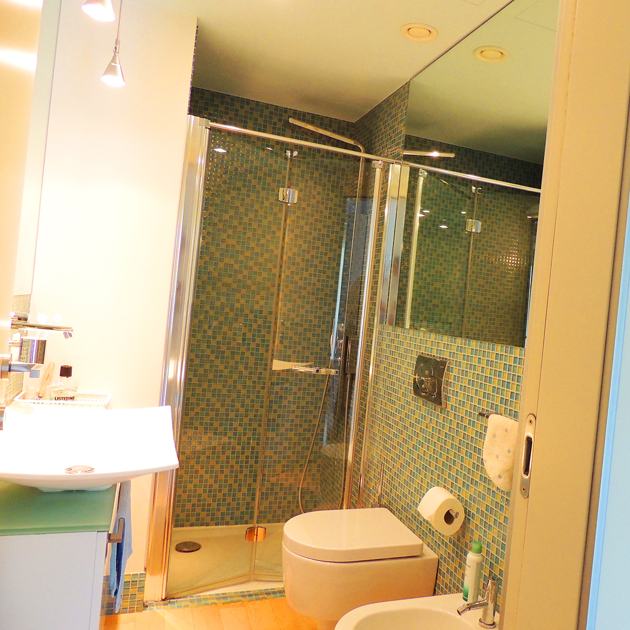 Modernes Badezimmer mit Glasdusche und Mosaikfliesen