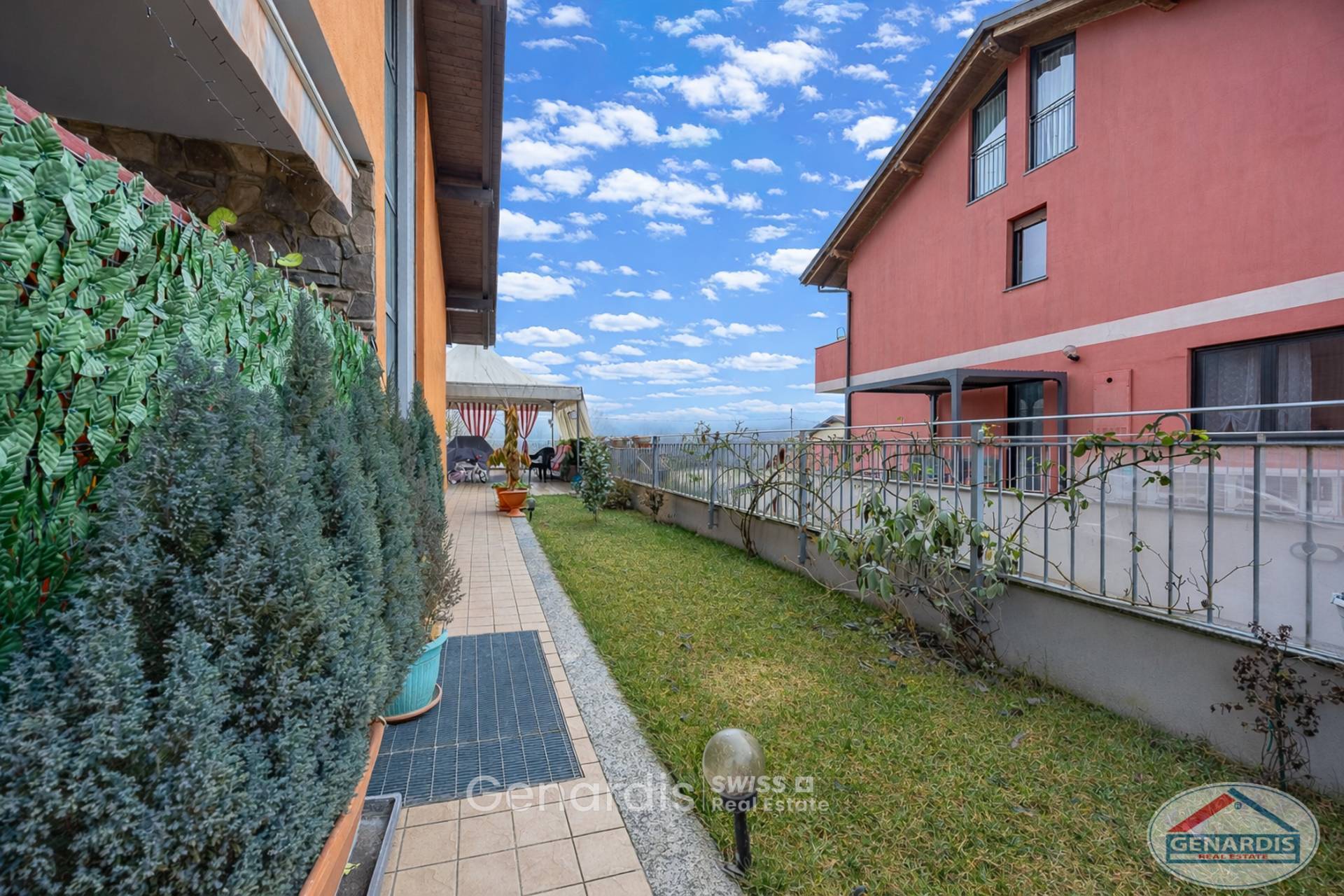 Außenbereich mit Garten und Terrasse zwischen zwei Gebäuden