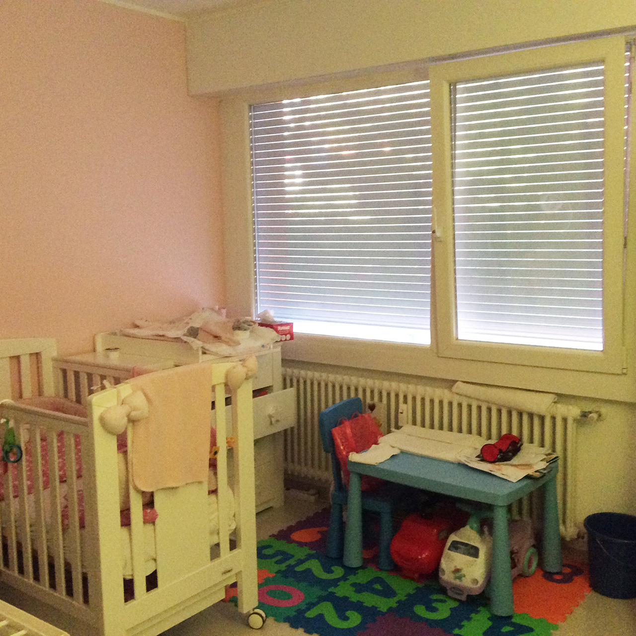Kinderzimmer mit zwei Fenstern und Spielmöbeln