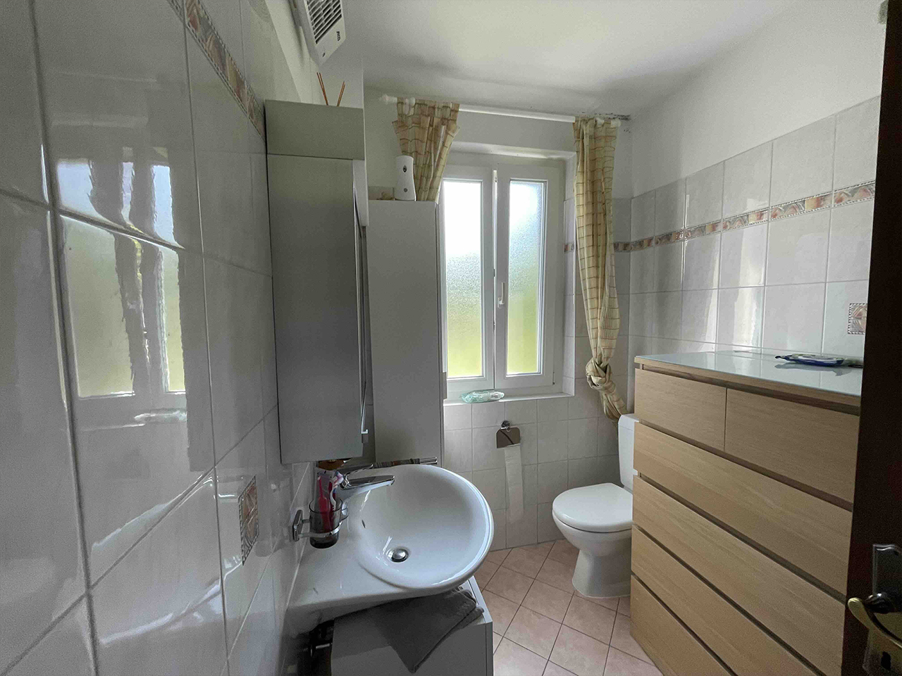 Kleines Badezimmer mit Fenster und Waschtisch