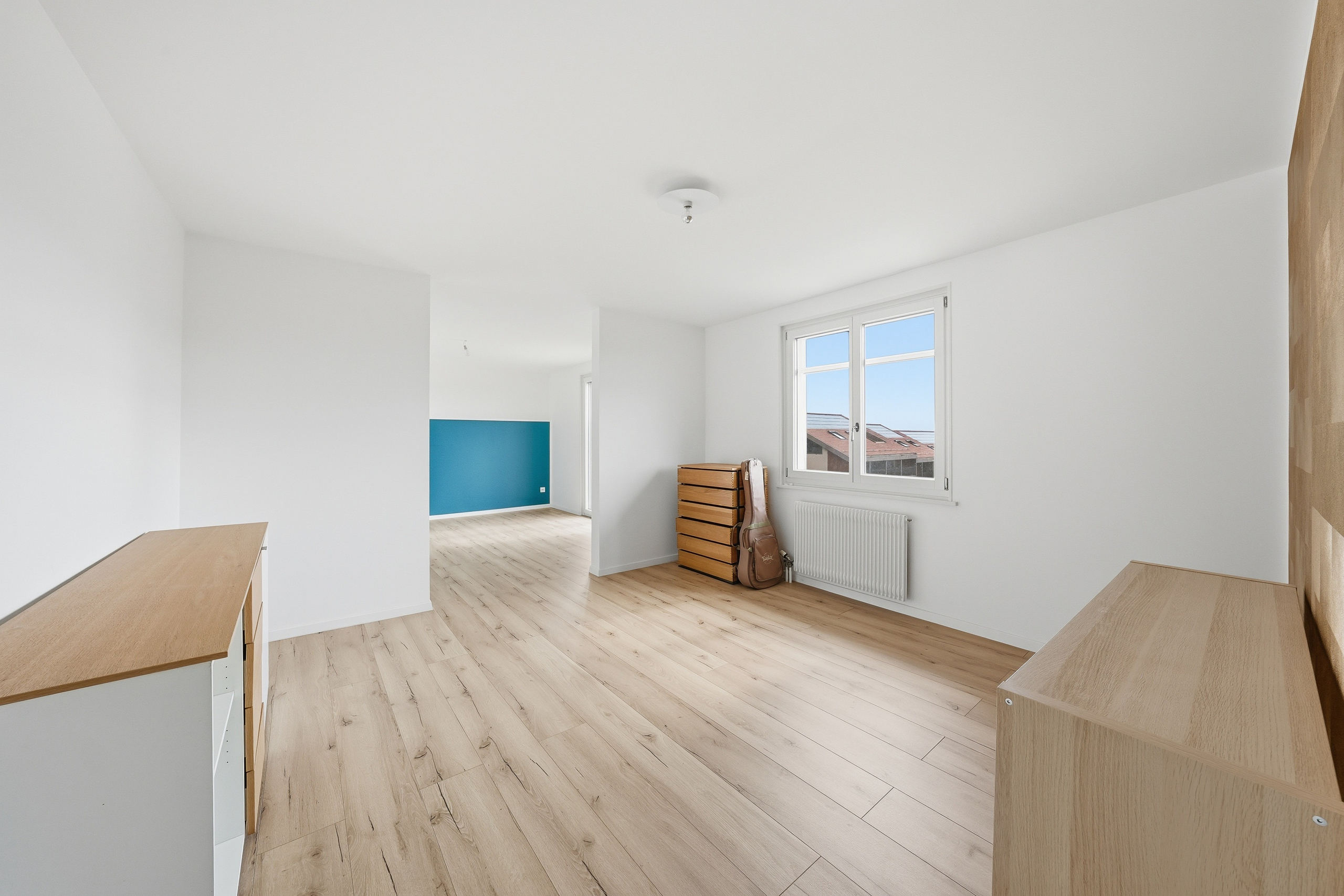 Helles, leeres Schlafzimmer mit Holzboden