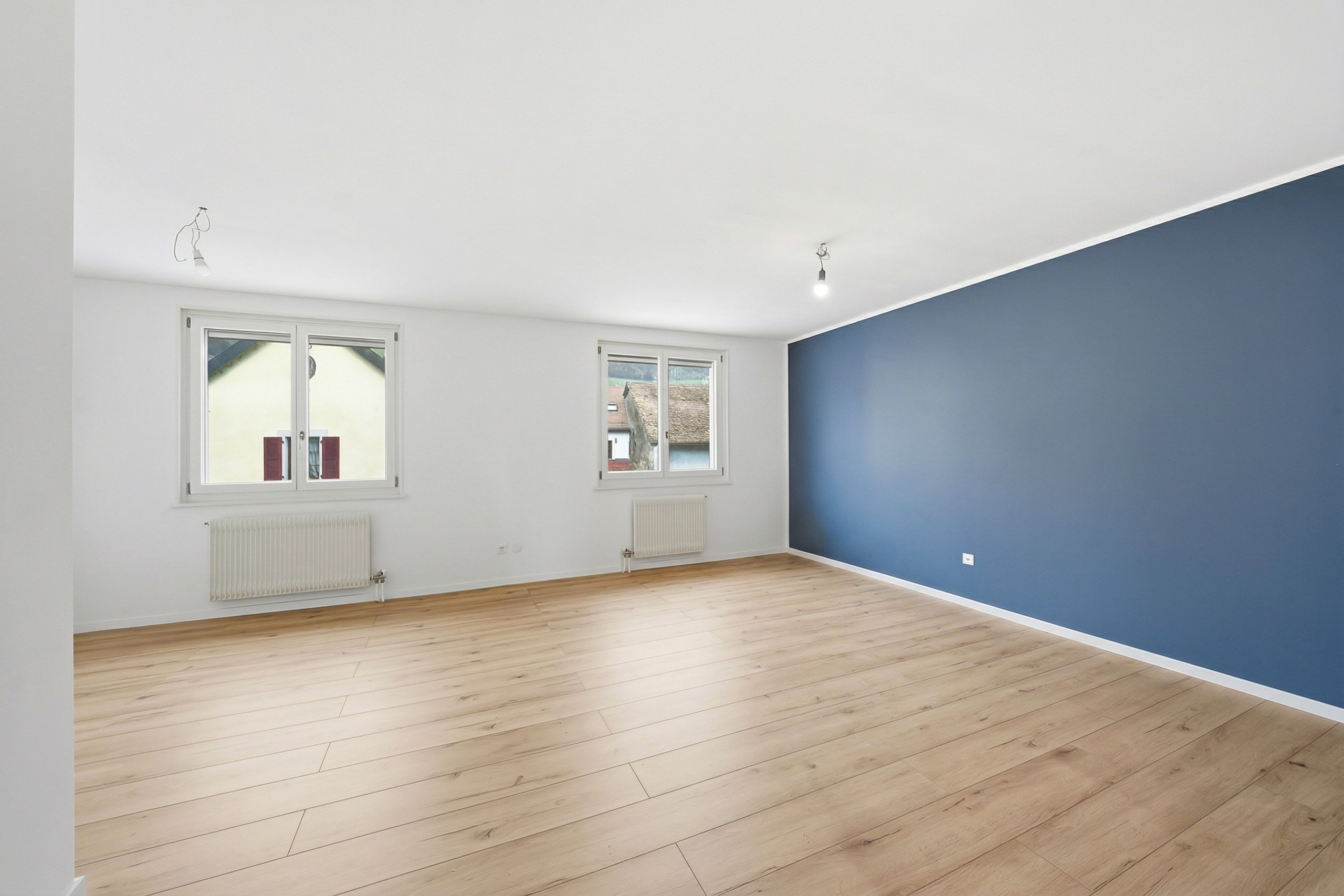 Helles, leeres Zimmer mit blauem Akzent