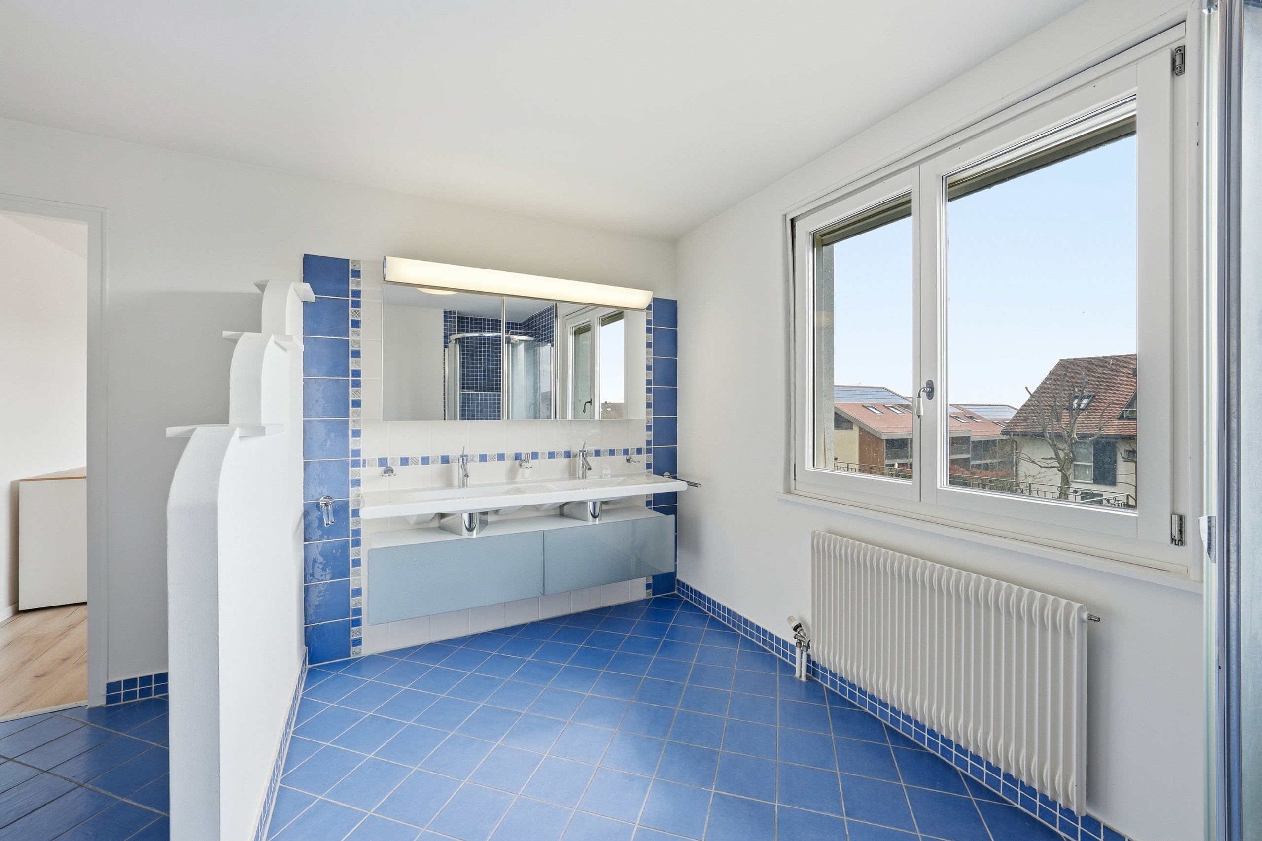 Badezimmer mit blauem Fliesenboden und Doppelwaschtisch