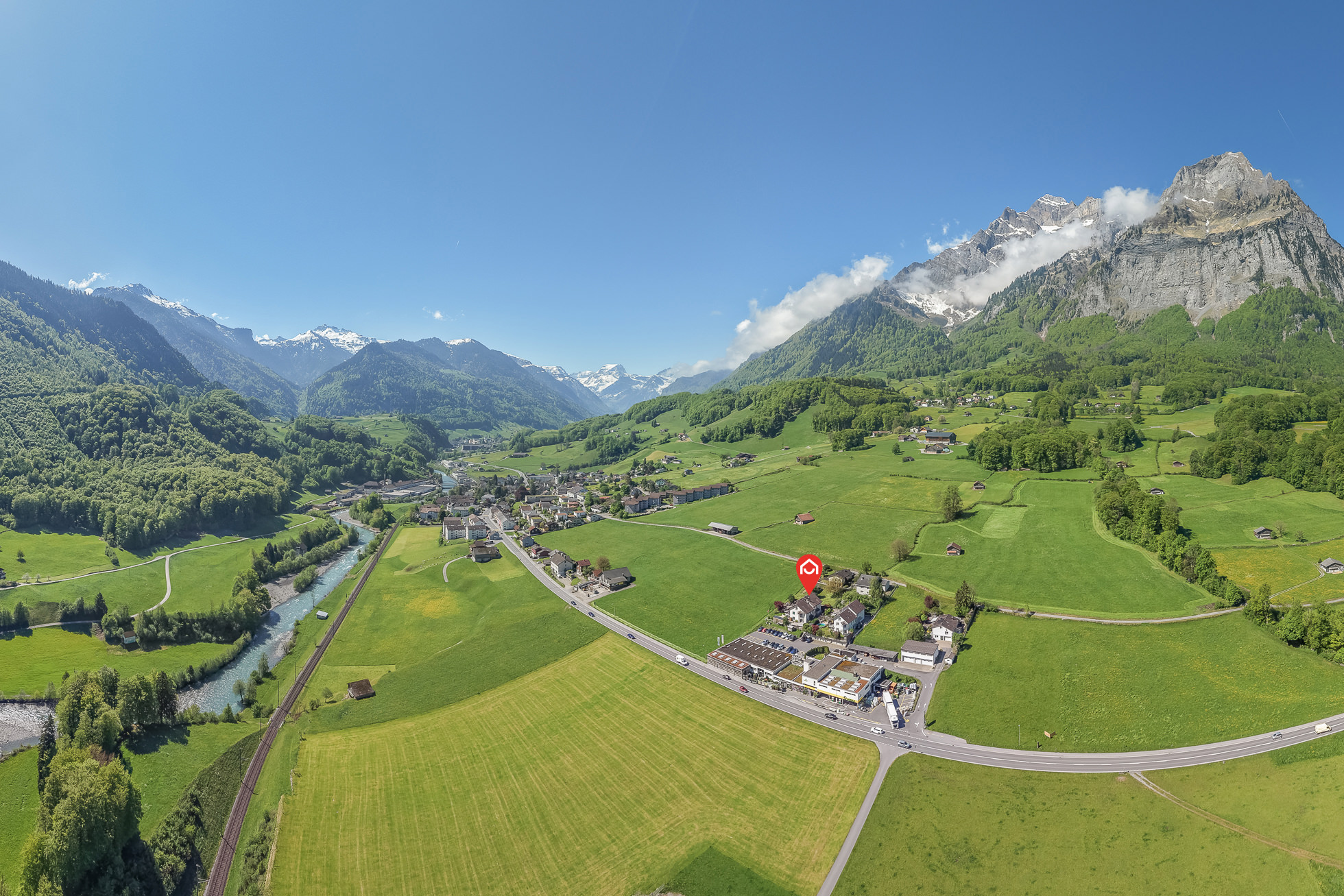Alpenlandschaft mit Tal, Dorf und Bergpanorama