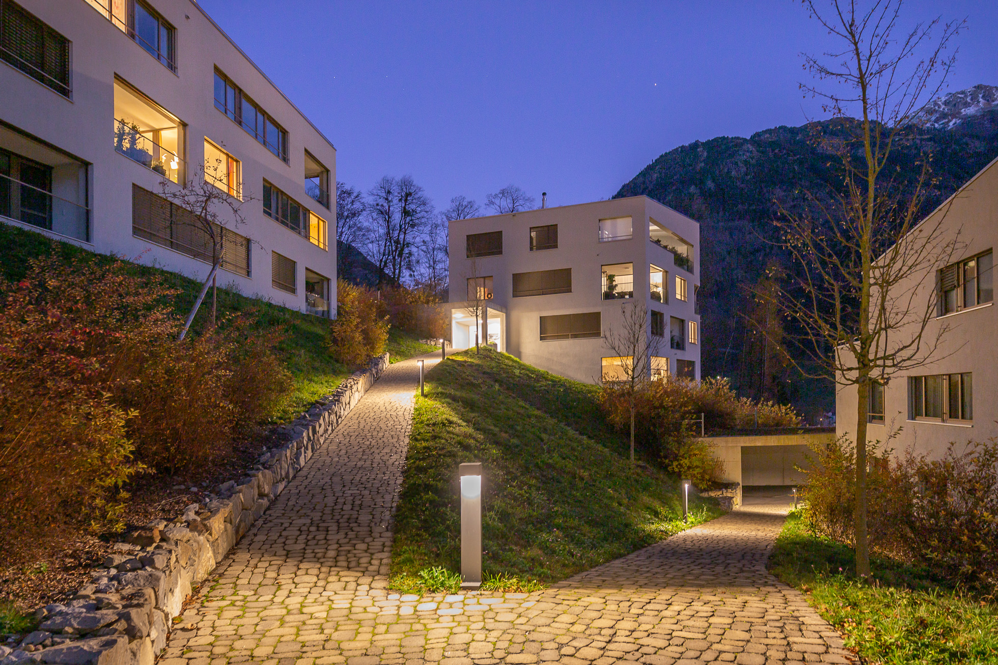 Moderne Wohnanlage am Hang bei Dämmerung